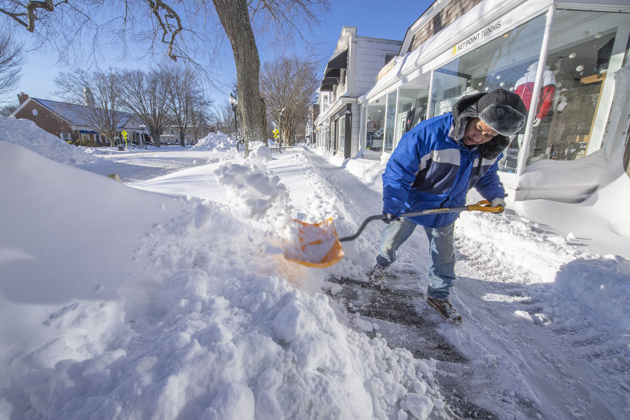Rudolfo Vasquez shovels snow from the sidewalk along Main Street following the January Blizzard of '22 on Sunday morning.  MICHAEL HELLER