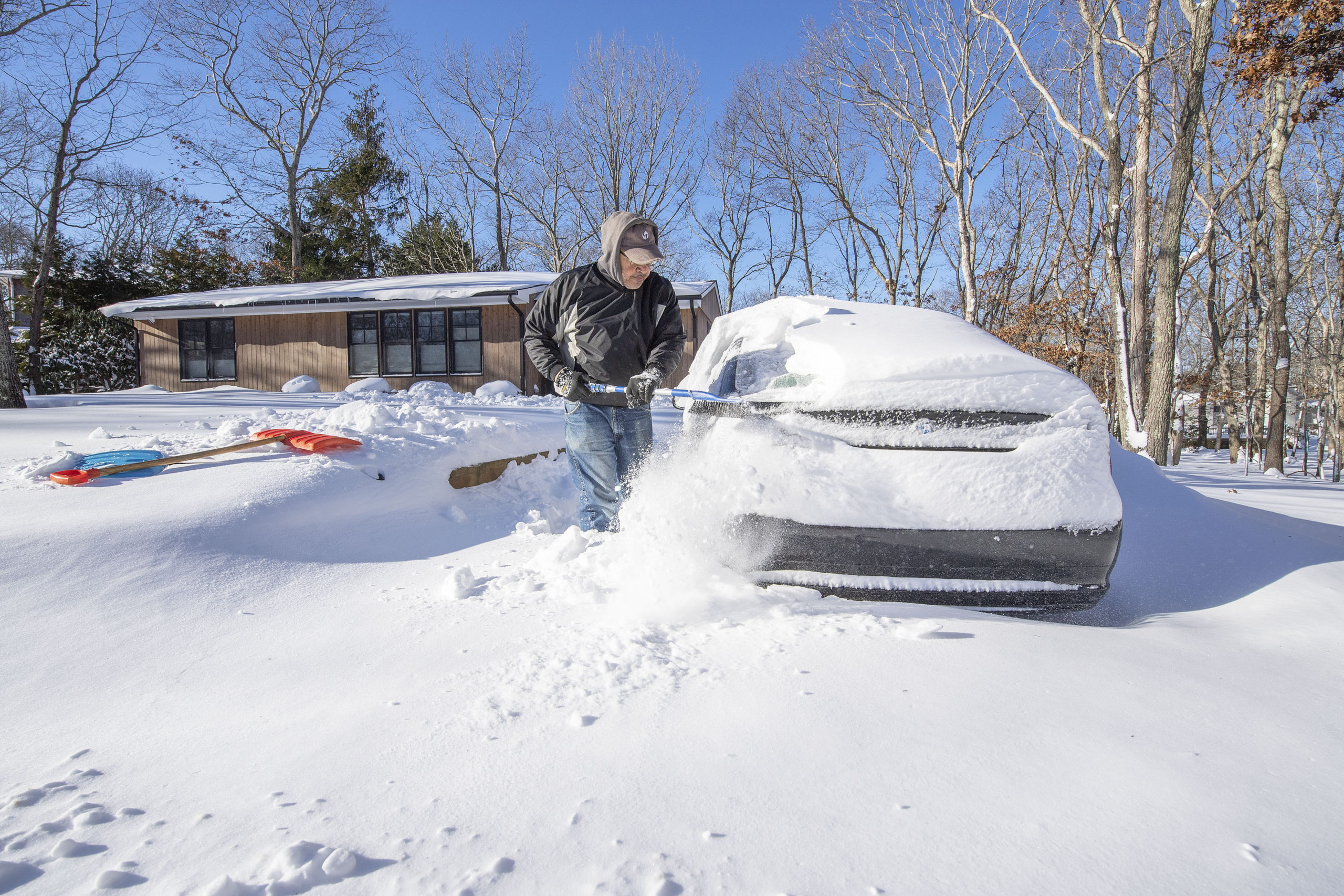 Cary White begins the process of digging out his car in front of his Beach Avenue home in Sag Harbor following the January Blizzard of '22 on Sunday morning.  MICHAEL HELLER