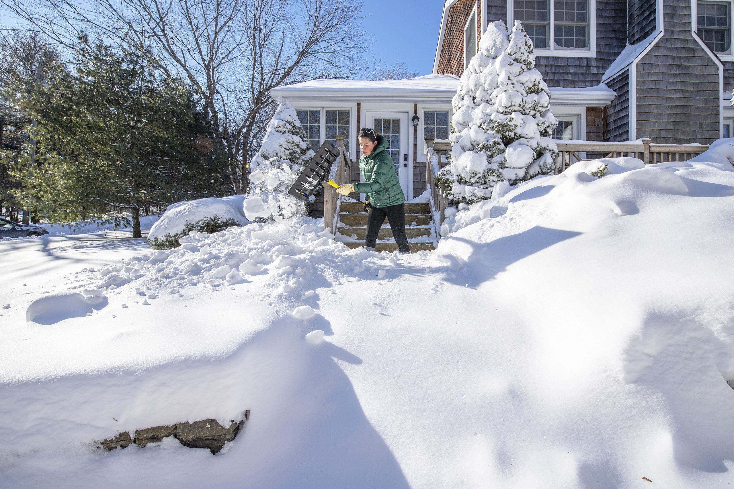 Hyatt Powers begins the arduous process of digging out the walk in front of her home in Sag Harbor following the January Blizzard of '22 on Sunday morning.  MICHAEL HELLER