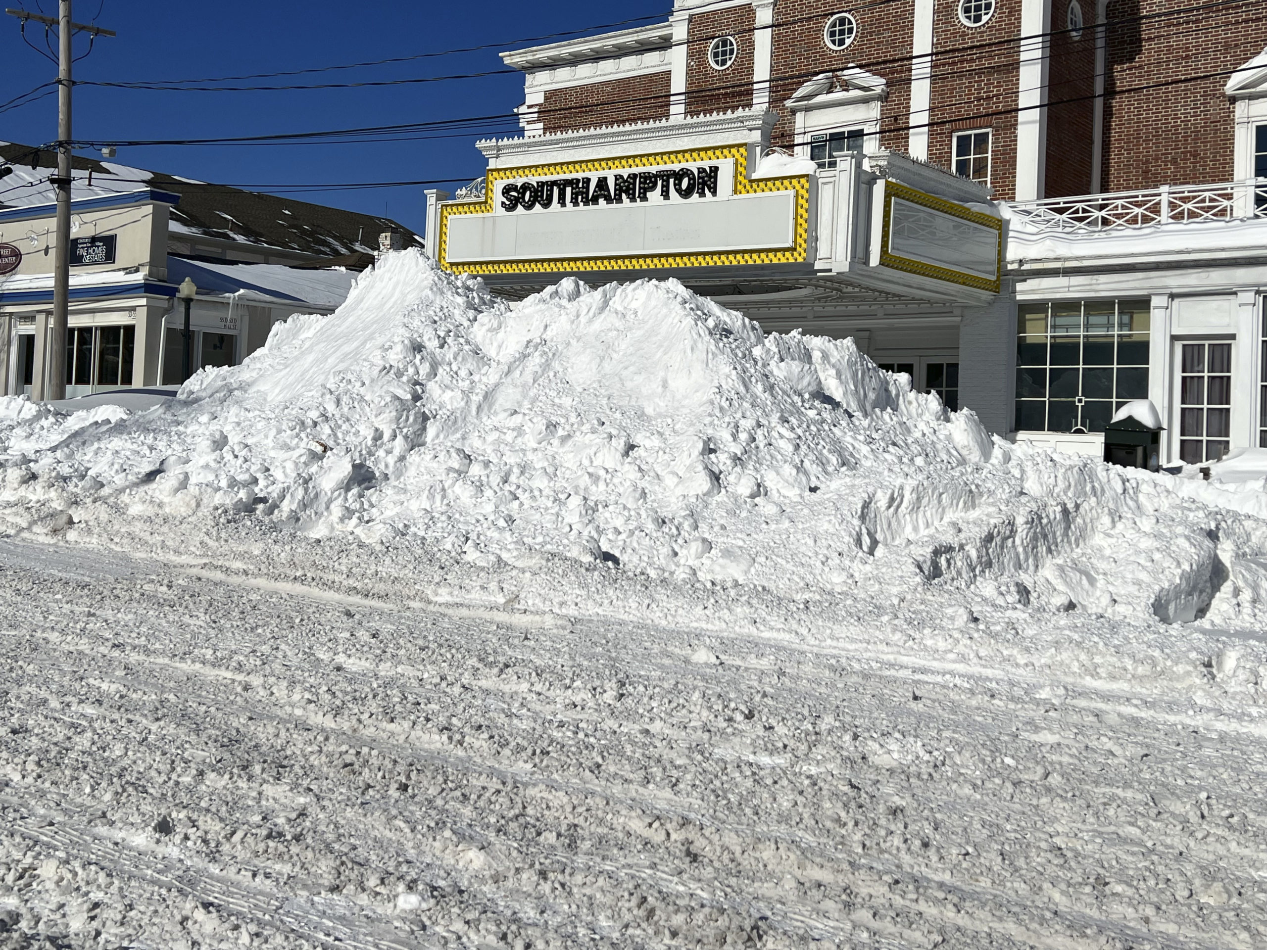 Snow that was cleared from the road is piled up to the marquee at the Southampton movie theater on Sunday.   DANA SHAW
