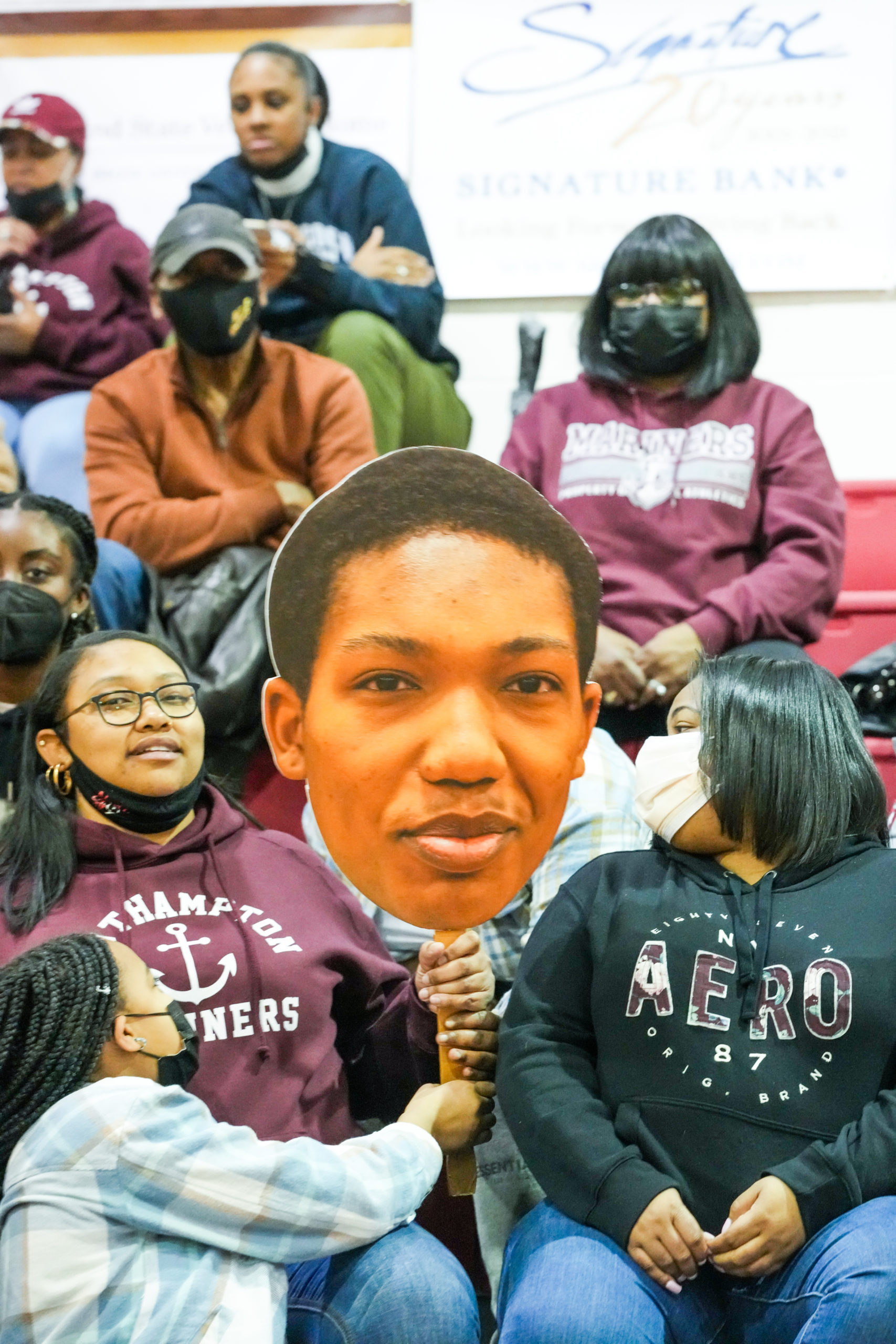 Fans hold up a Naevon Jenkins Fathead.