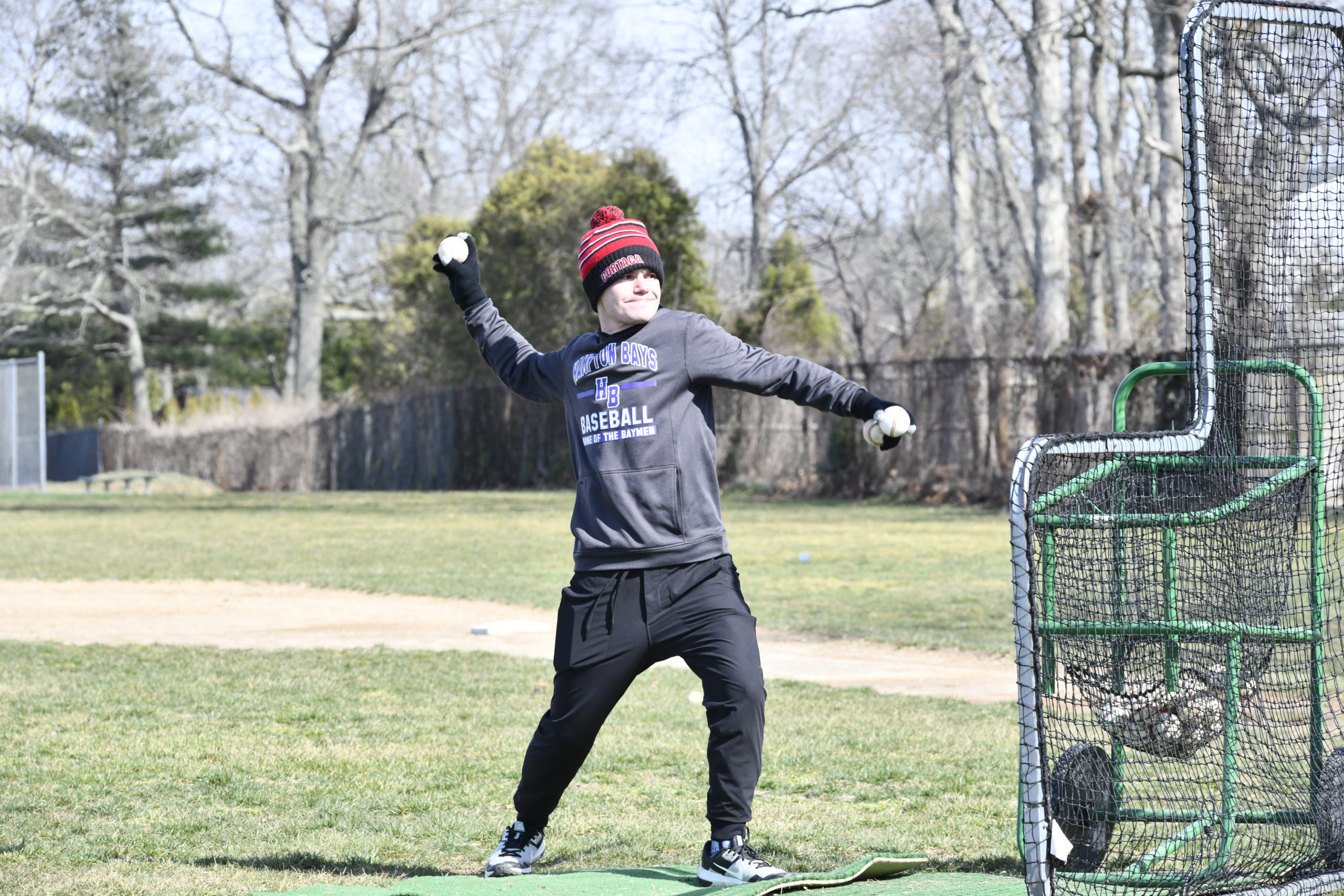 Assistant coach Andrew Hafemeister throws some batting practice on Monday.  DANA SHAW