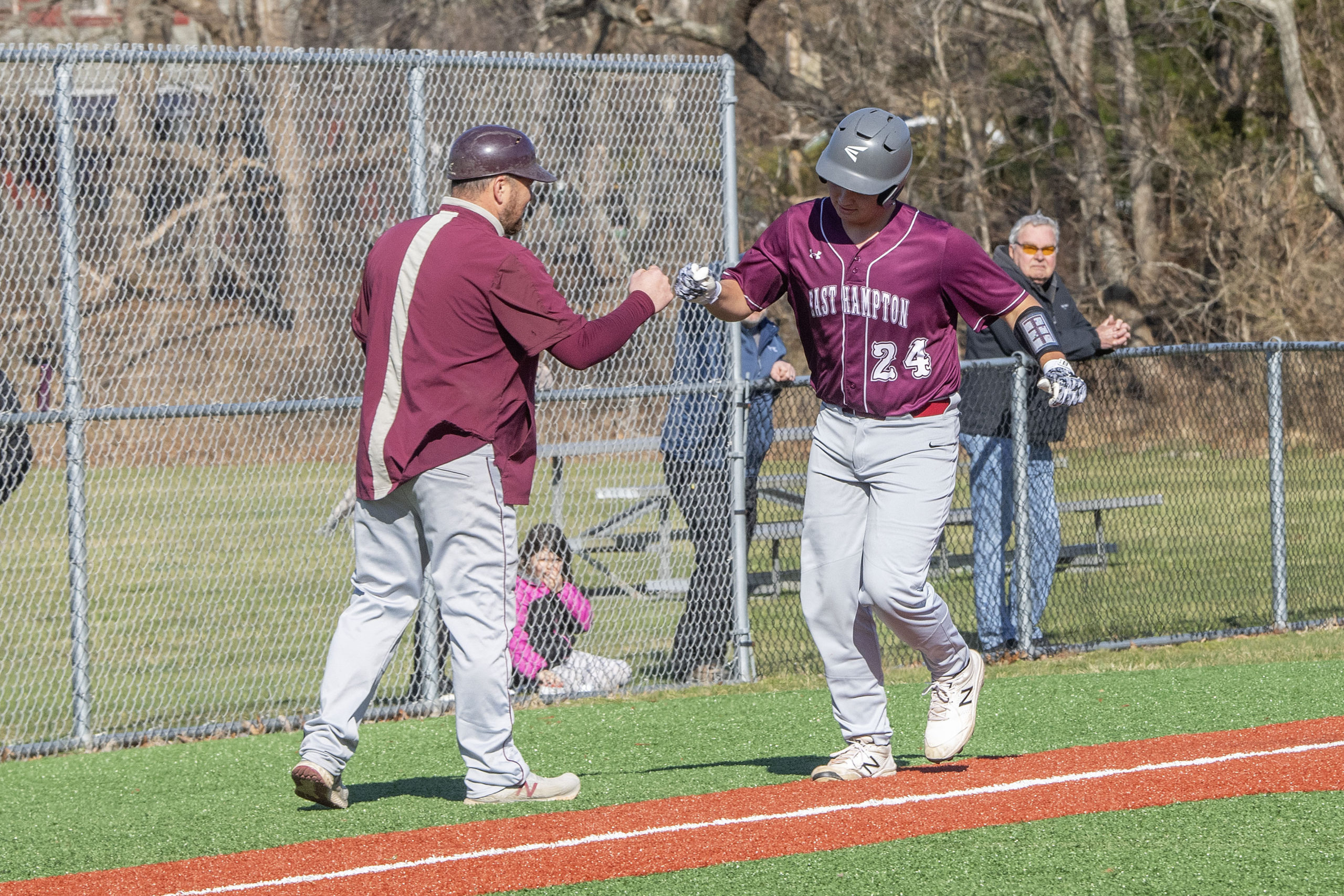 East Hampton's Carter Dickinson gets a fist-bump from head coach Vinny Alversa rounding third base coach after crushing a three-run home run on Friday.   MICHAEL HELLER