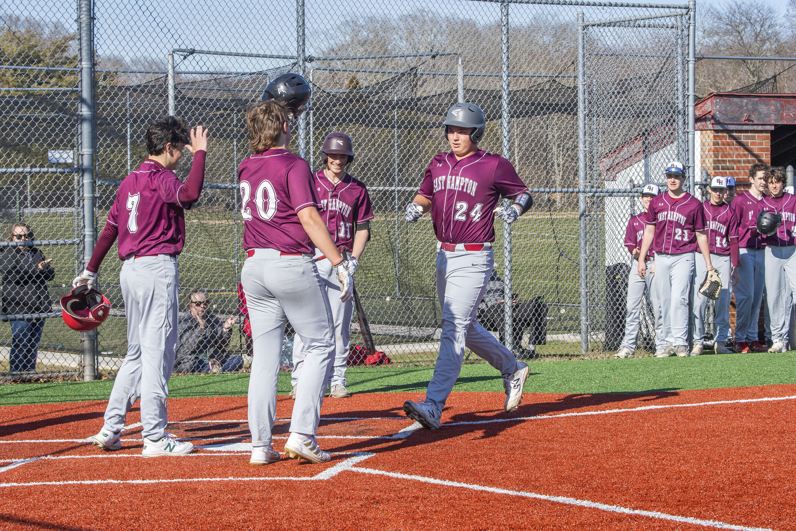 East Hampton's Carter Dickinson is welcomed home by his teammates after crushing a three-run homer.    MICHAEL HELLLER