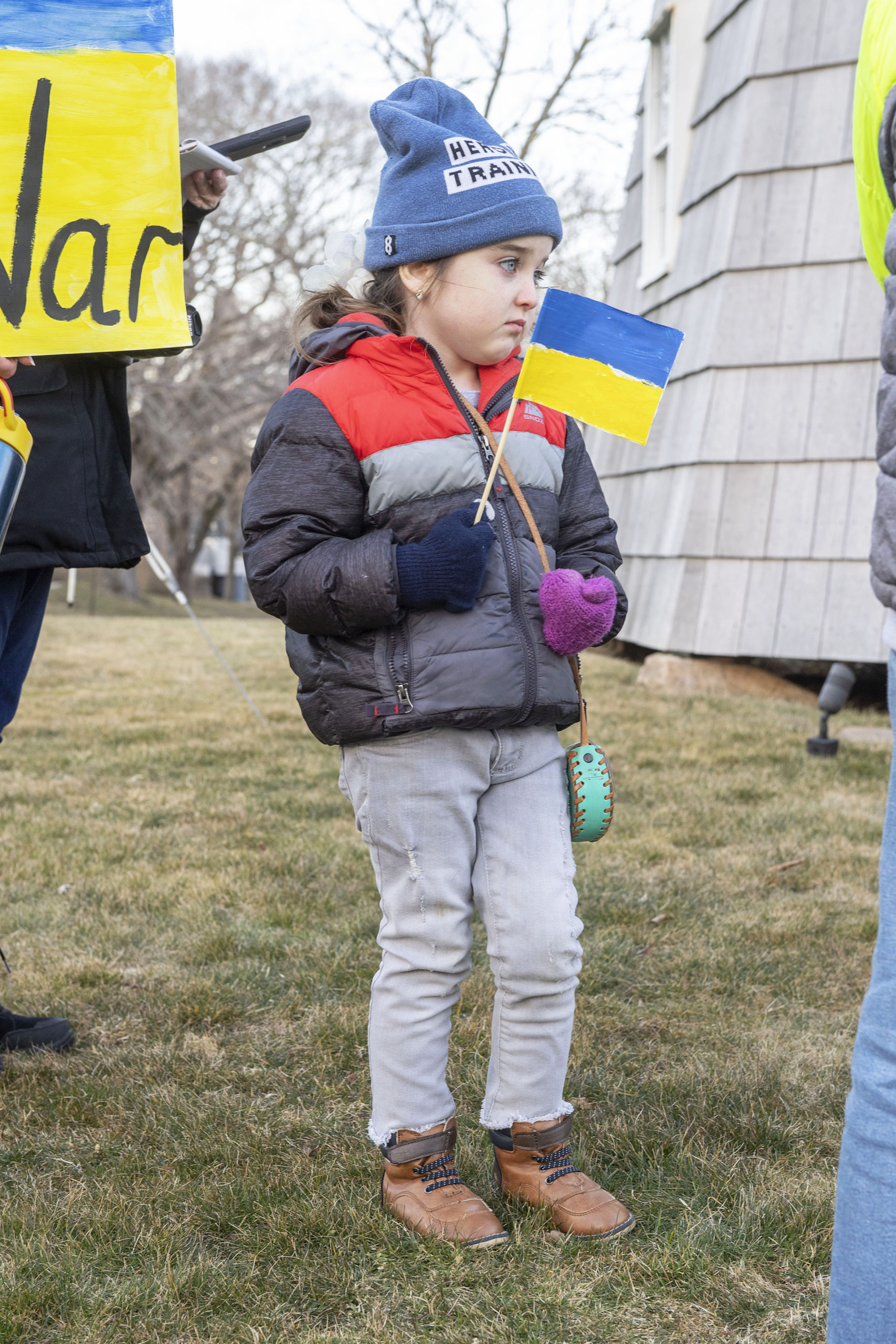 Zoe Ostrof, holding a Ukrainian flag that she made herself, looks on during a rally last Thursday in support of Ukraine on the Hook Mill Village Green in East Hampton. MICHAEL HELLER