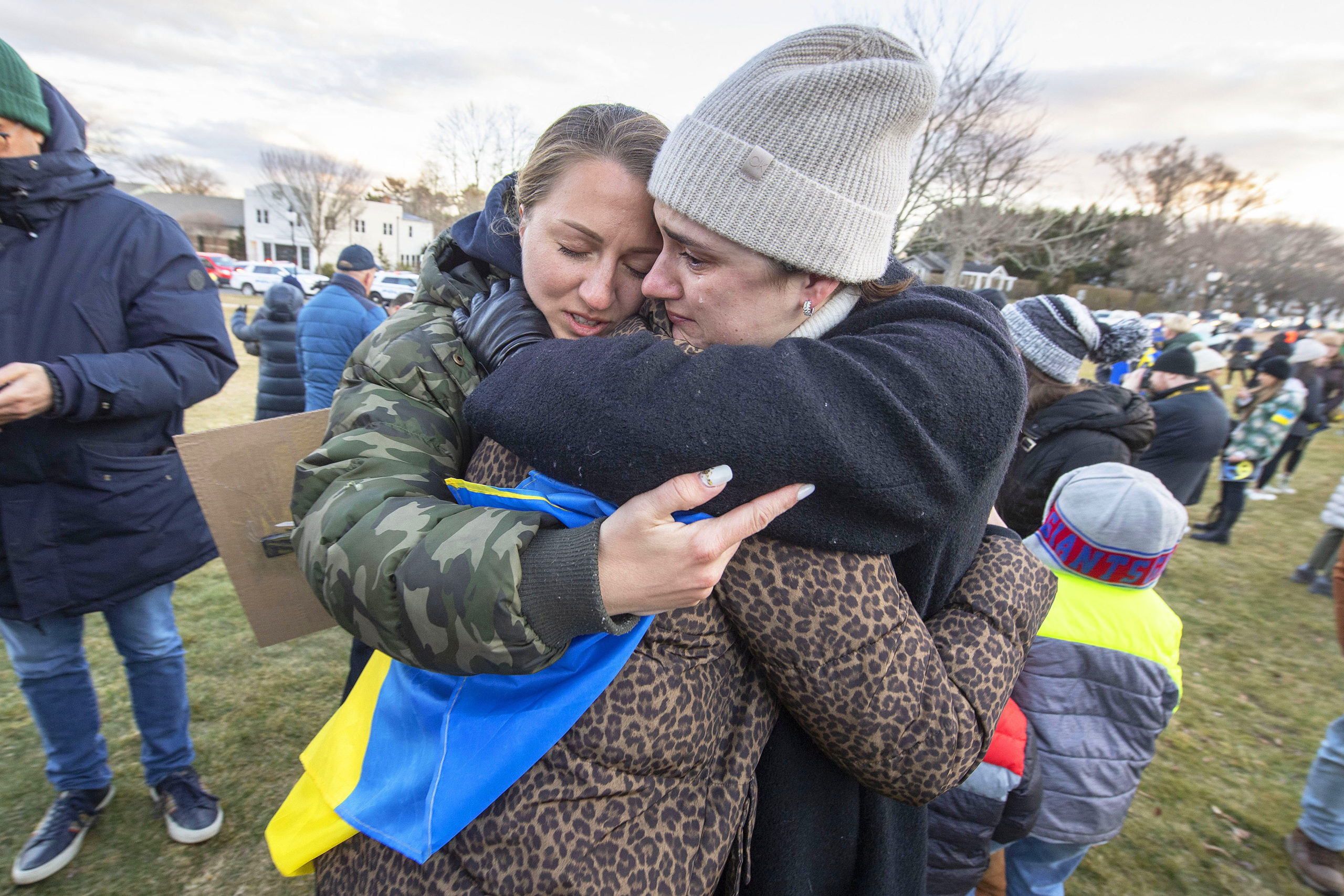 Vira Palamarchuk, center, whose father is fighting on the front lines in Ukraine, is comforted by her mother, Anya, left, and a close friend, right, who happens to be Russian, during a rally in support of Ukraine last Thursday on the Hook Mill Village Green in East Hampton.  MICHAEL HELLER