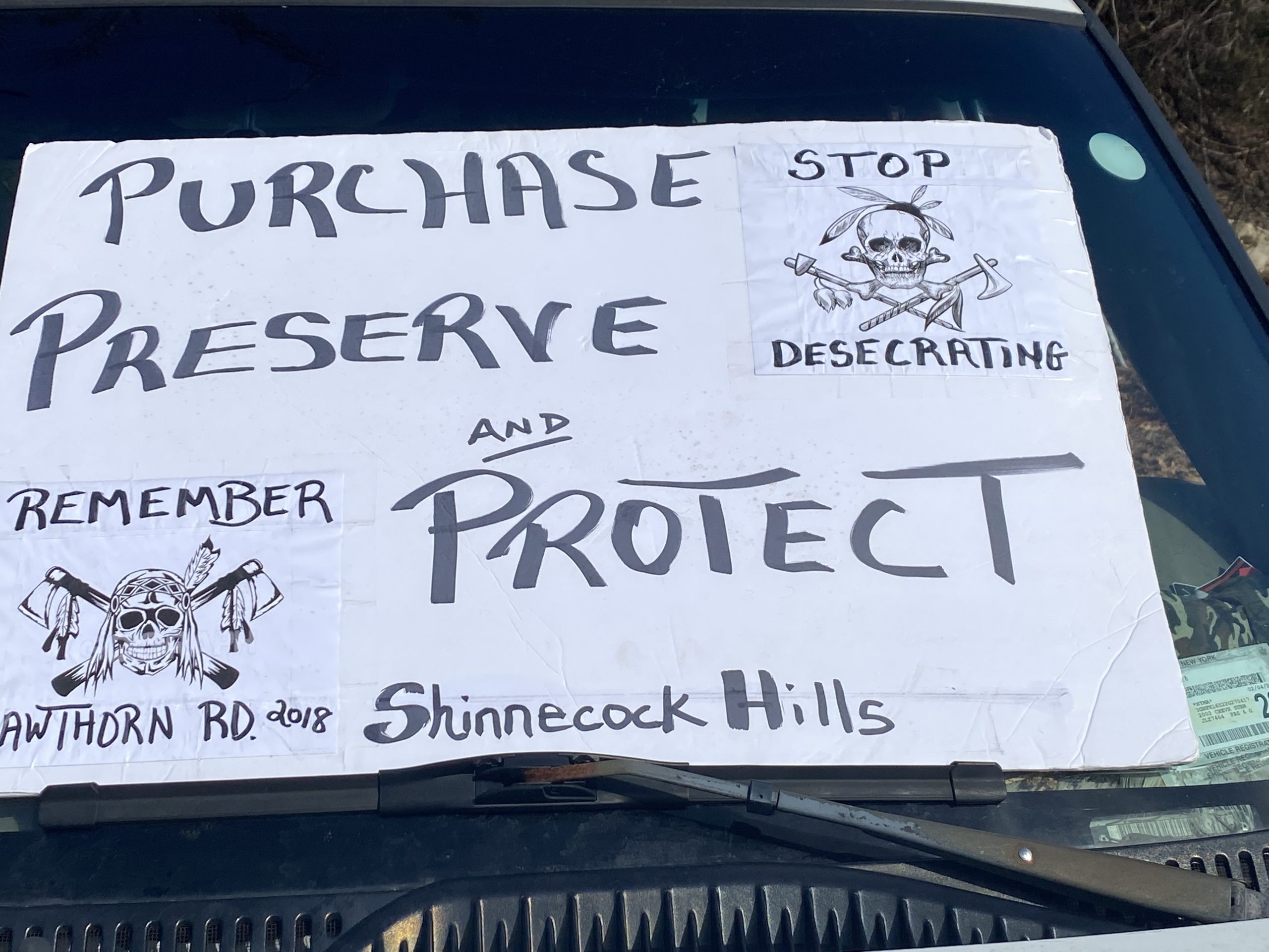 A sign in the windshield of a car urges Southampton Town to preserve sacred land in Shinnecock Hills. COURTESY HEIDI RAIN OLESZCZUK