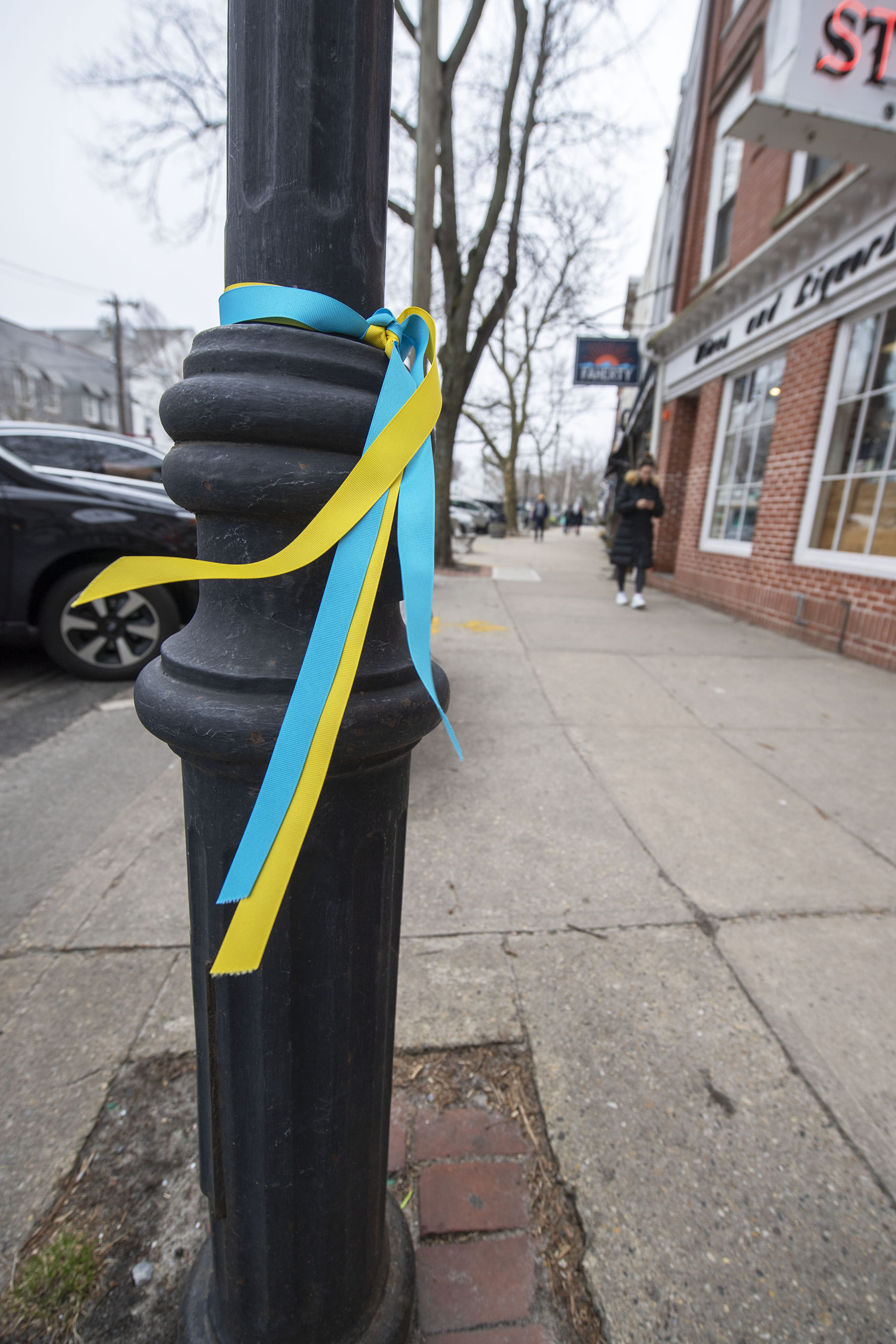 Blue and yellow ribbons were tied around all the street lampposts on Main Street in Sag Harbor in support of Ukraine, as seen on Monday. MICHAEL HELLER