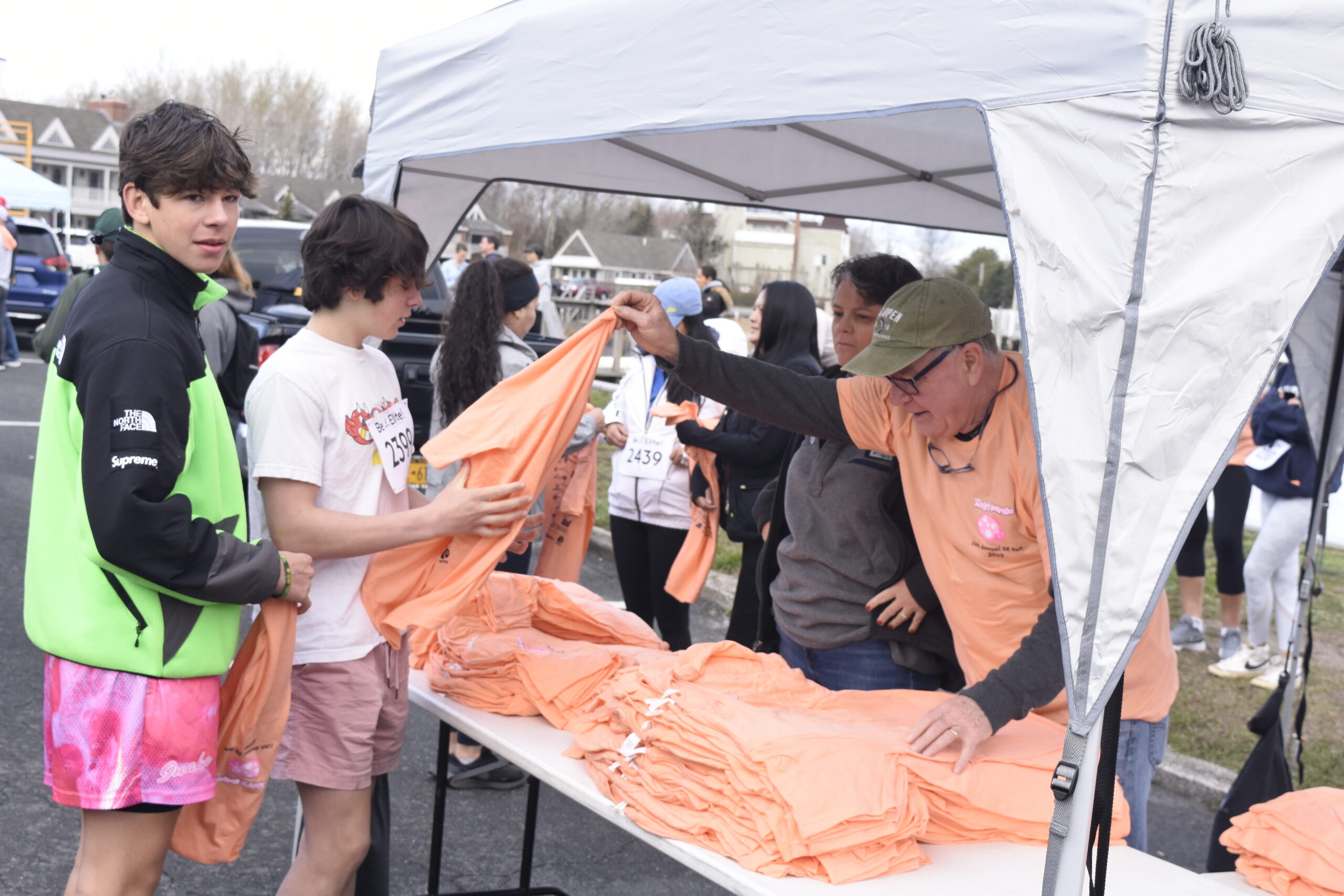 Volunteers hand out shirts to racers.    DREW BUDD