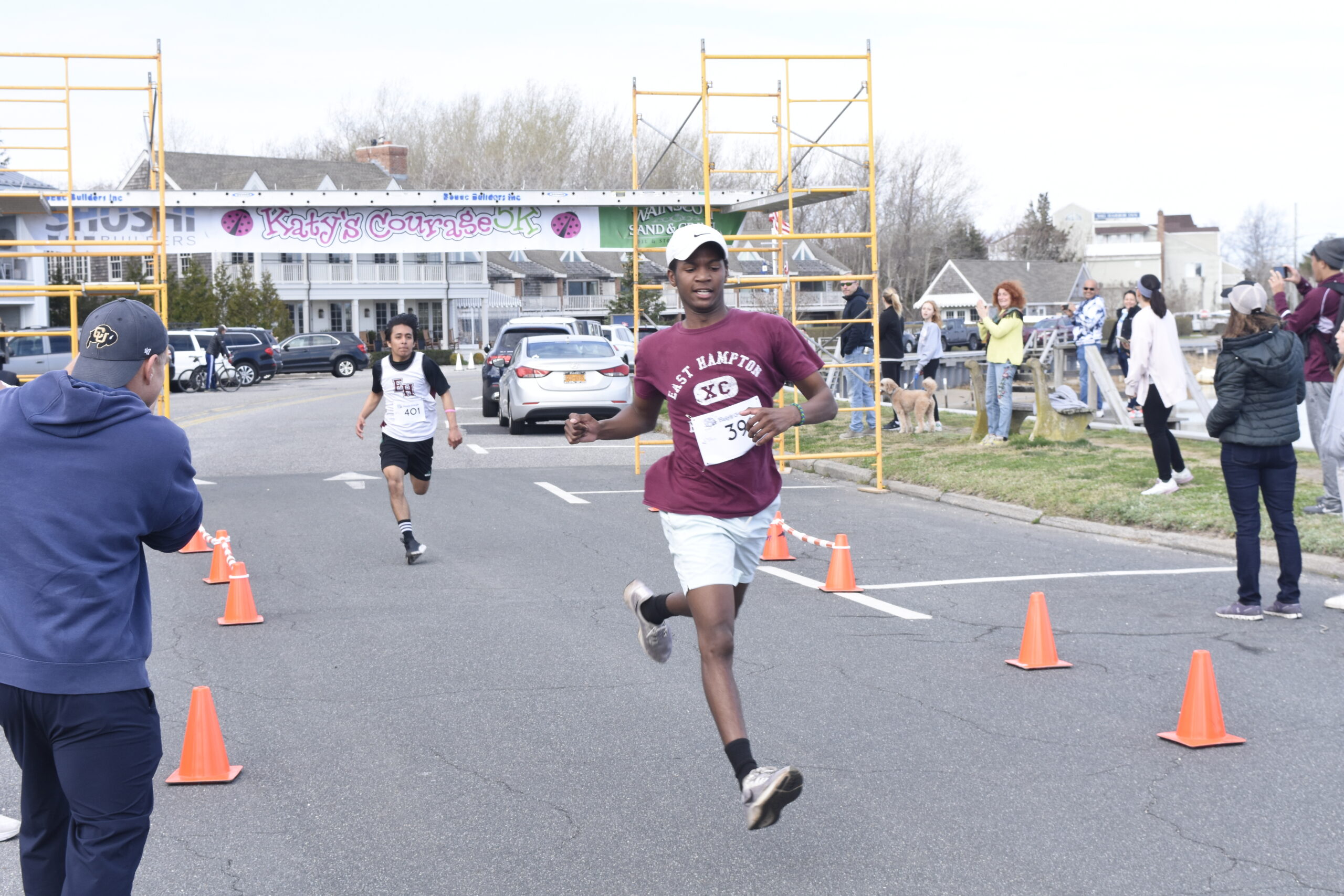 East Hampton's Amari Gordon, and teammate Diego Rojas behind him, cross the finish line.   DREW BUDD