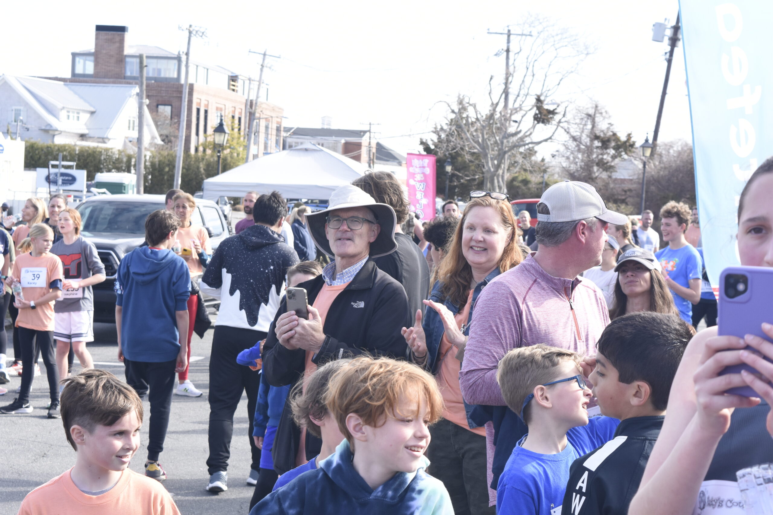 Jim Stewart and Brigid Collins, parents of the late Katy Stewart, welcome in runners as they cross the finish line on Saturday.   DREW BUDD