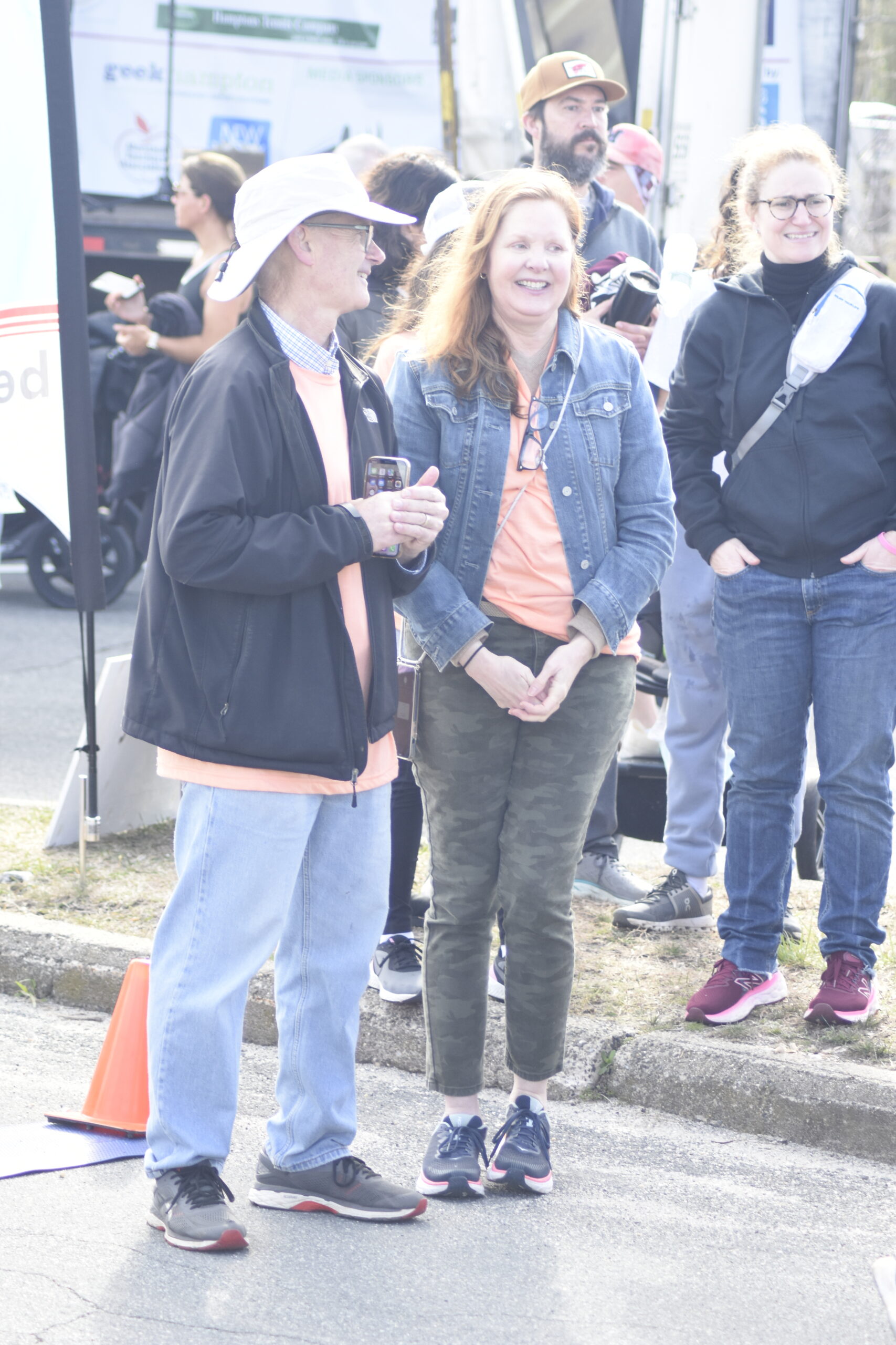 Jim Stewart and Brigid Collins, parents of the late Katy Stewart, welcome in runners as they cross the finish line on Saturday.   DREW BUDD