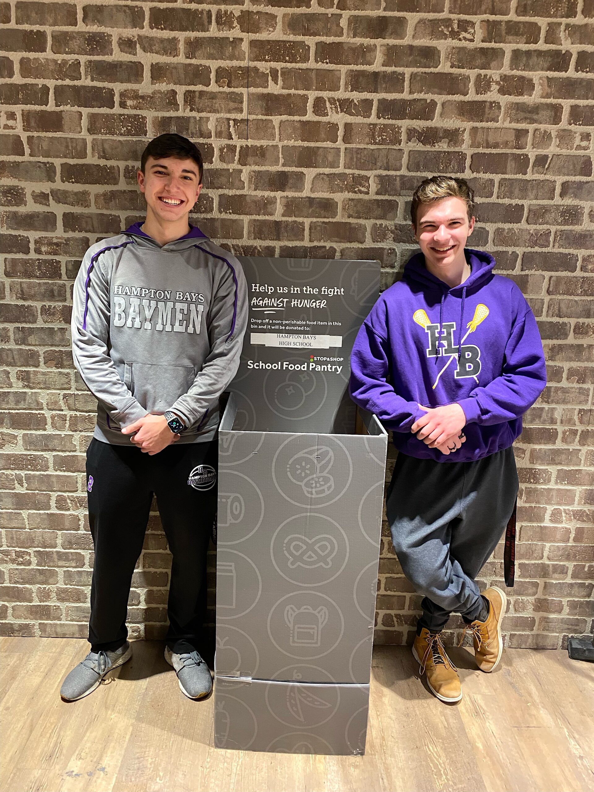 Hampton Bays seniors James Kiernan and Ben Madison at the Food For Thought donation bin inside the Hampton Bays Stop & Shop. HAMPTON BAYS SCHOOL DISTRICT