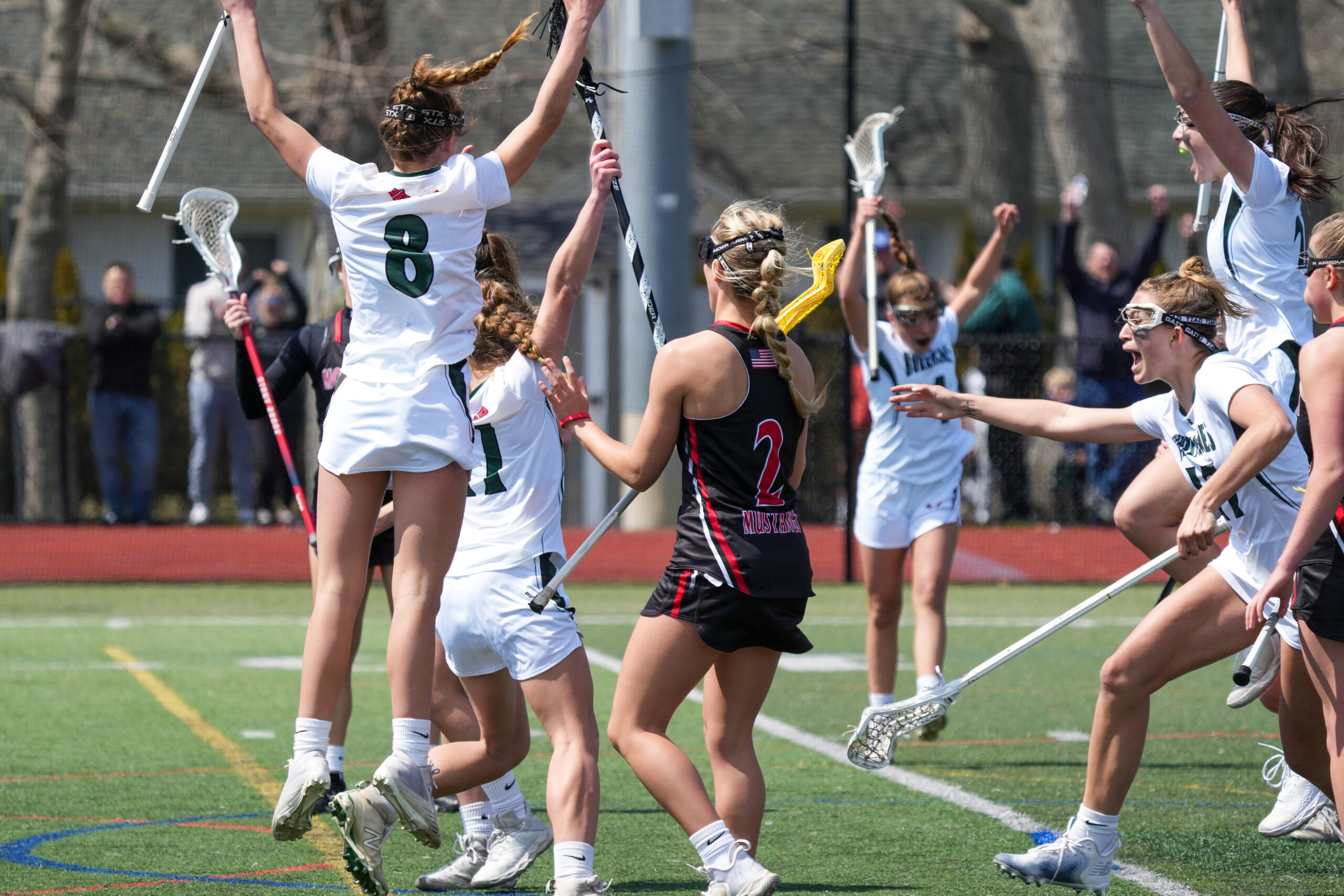 Westhampton Beach's girls lacrosse team celebrates senior Lily Berchin's eventual game-winning goal. RON ESPOSITO