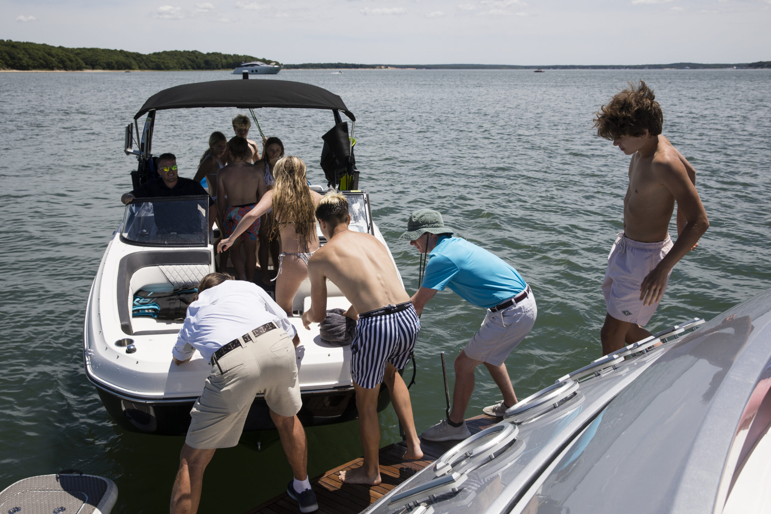 Guests jump on a smaller boat to go tubing on a trip with Yacht Hampton. LORI HAWKINS