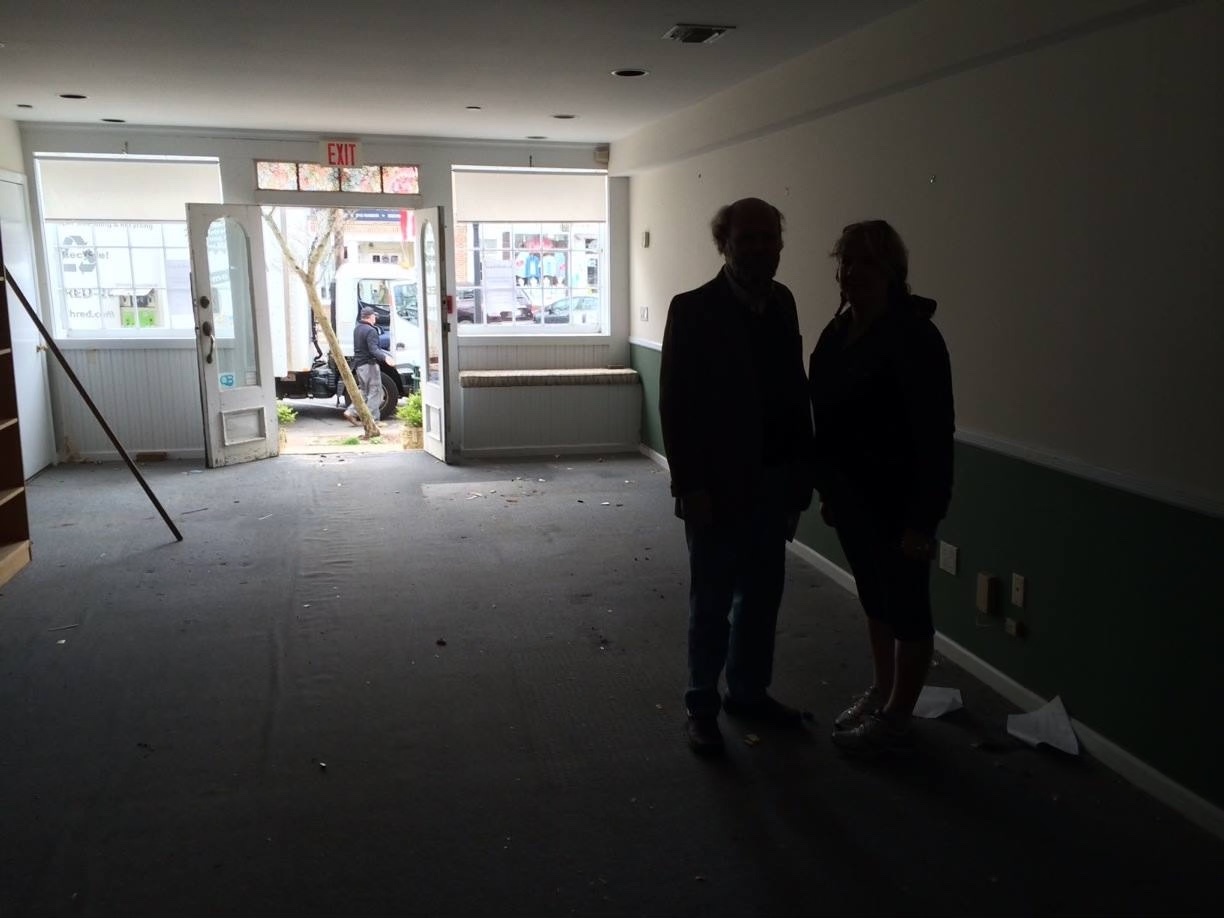 Bryan Boyhan and Annette Hinkle standing in the empty Main Street newsroom of The Sag Harbor Express just before the move upstairs in 2014.