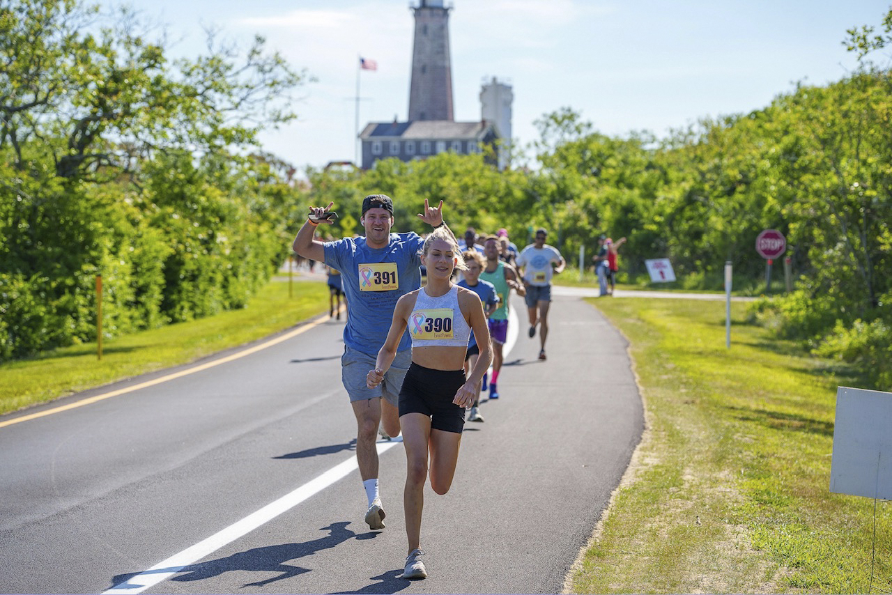 Rebecca Deitch, the top female finisher at the Beacon of Hope 5K, heads away from the Montauk Point Lighthouse toward Camp Hero on Saturday.    LONG ISLAND RUNNING