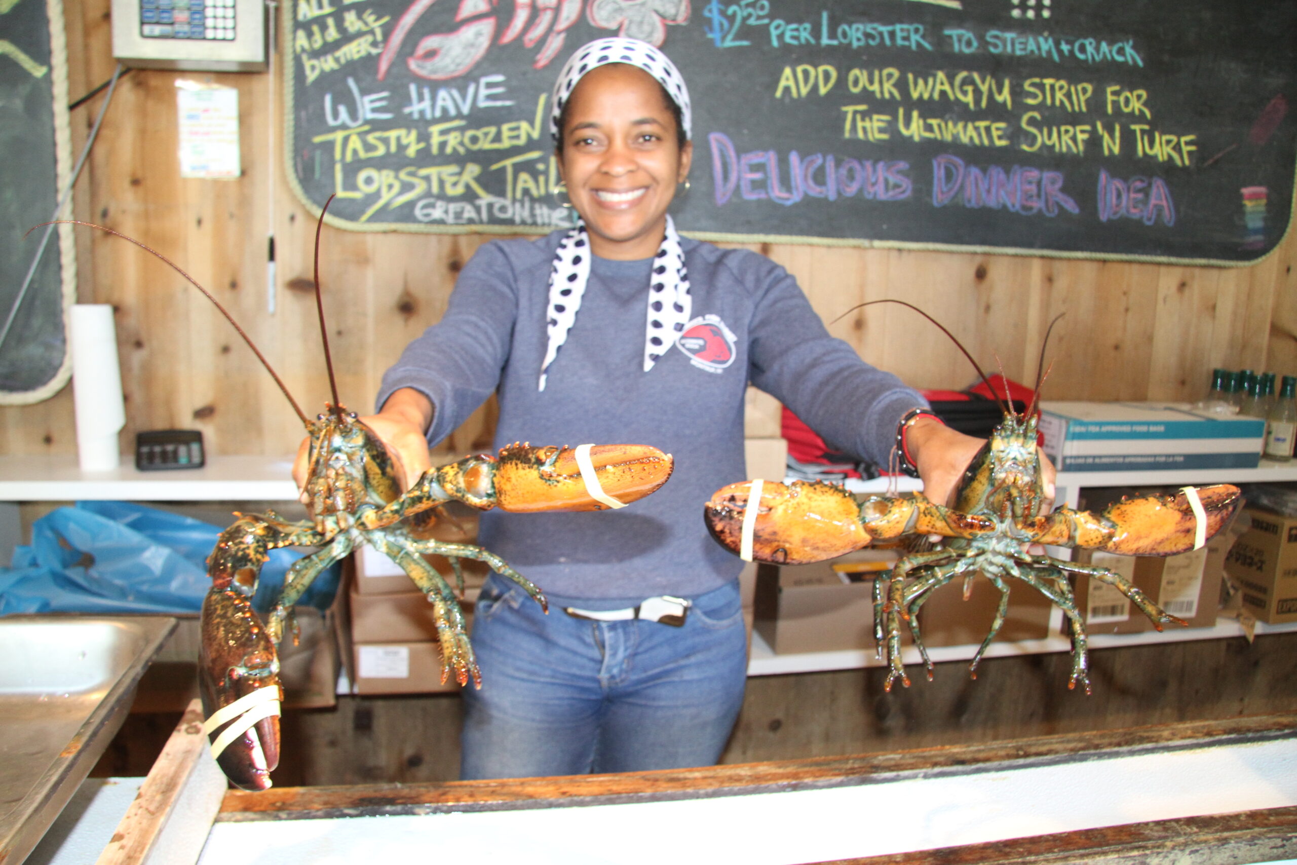 Emlly Montas with a couple of Gosman's Fish Market's liveliest lobsters.