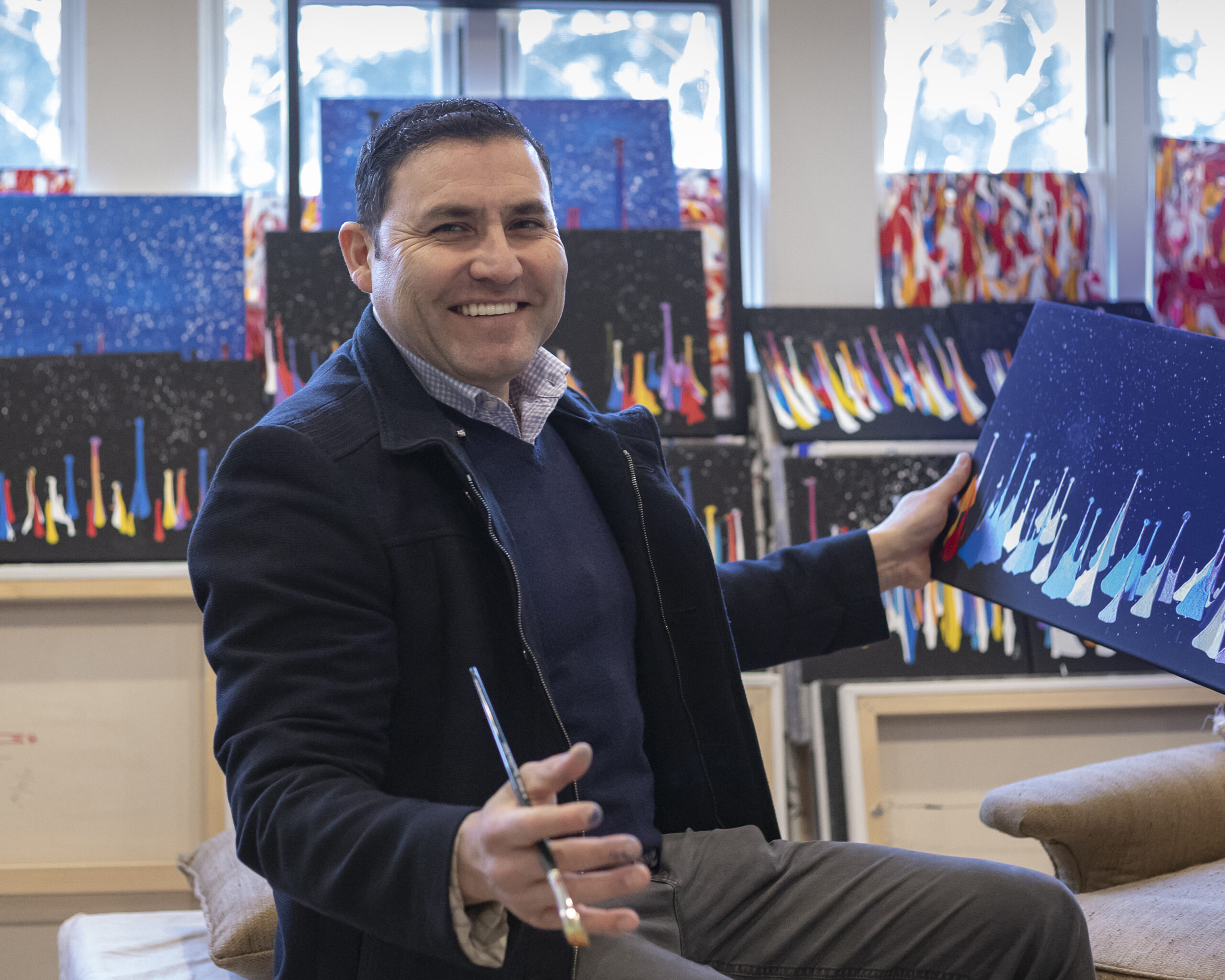 Artist Oscar Molina with one of his paintings. COURTESY THE ARTIST