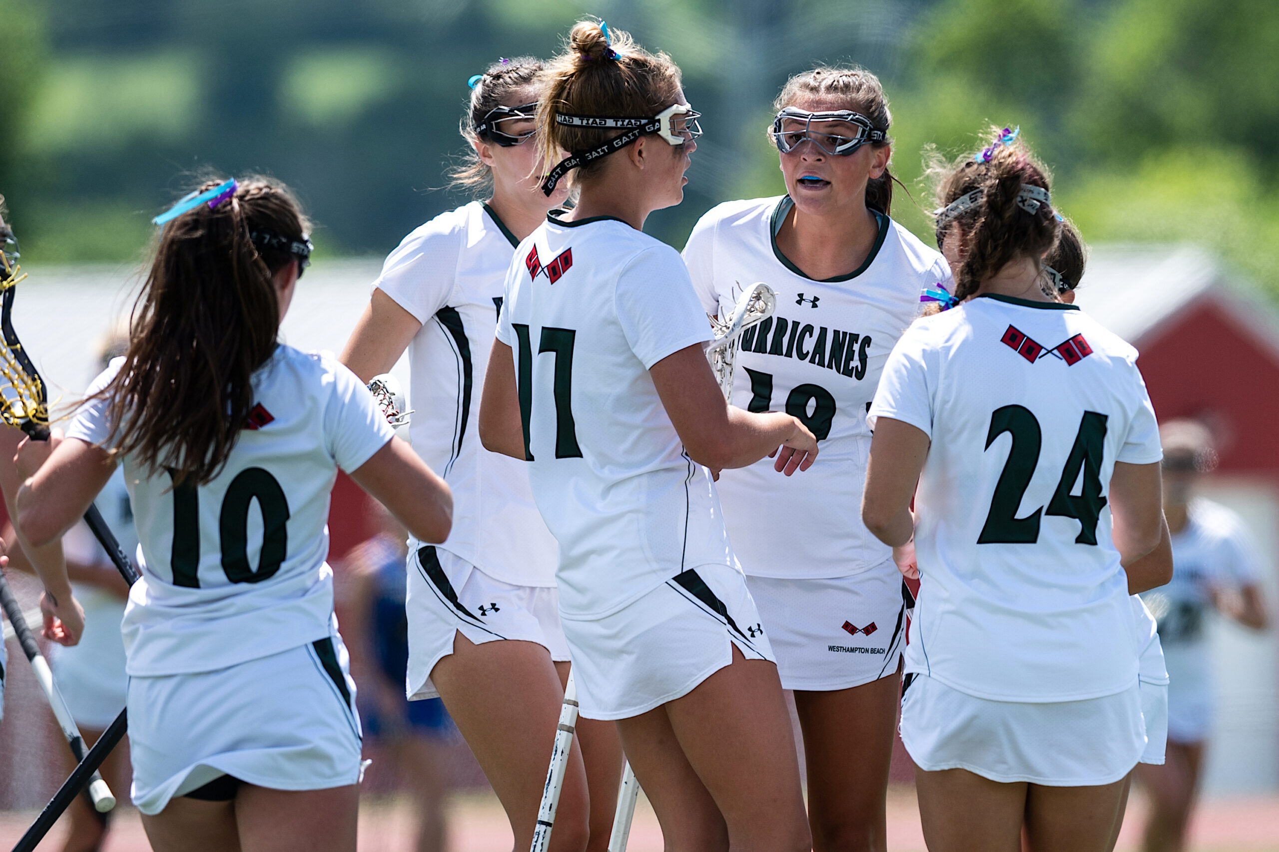 Members of Westhampton Beach's girls lacrosse team huddle together. TODD MICHALEK