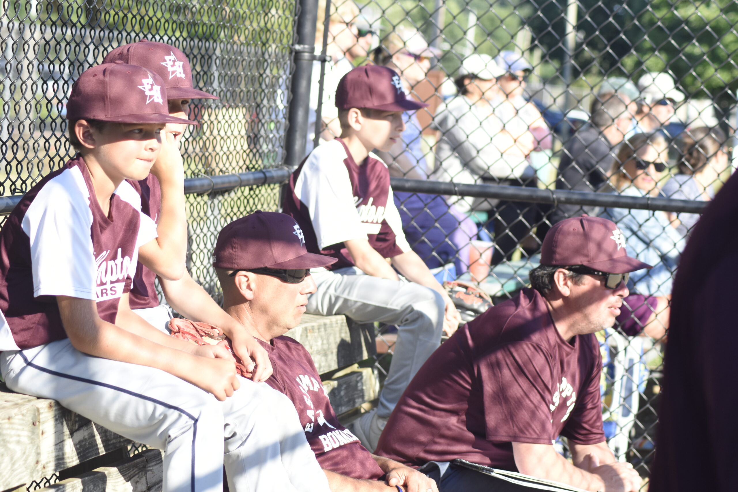 East Hampton Majors All-Stars and coaches look on intently from the dugout.   DREW BUDD