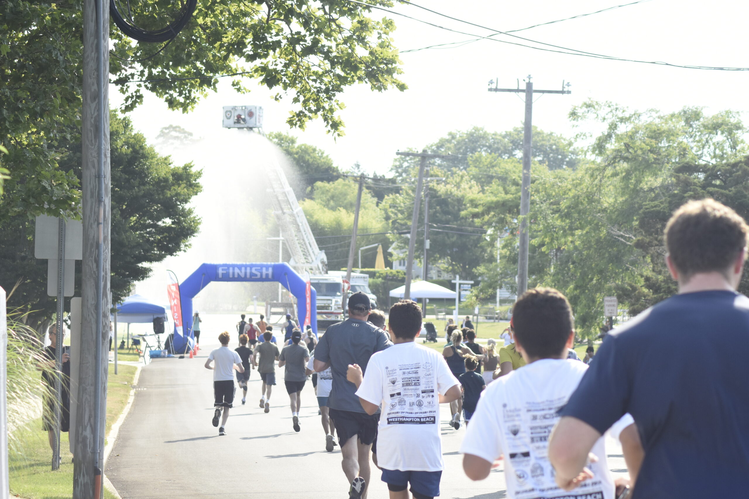 Runners and walkers make their toward the shower provided by the Westhampton Beach Fire Department.    DREW BUDD