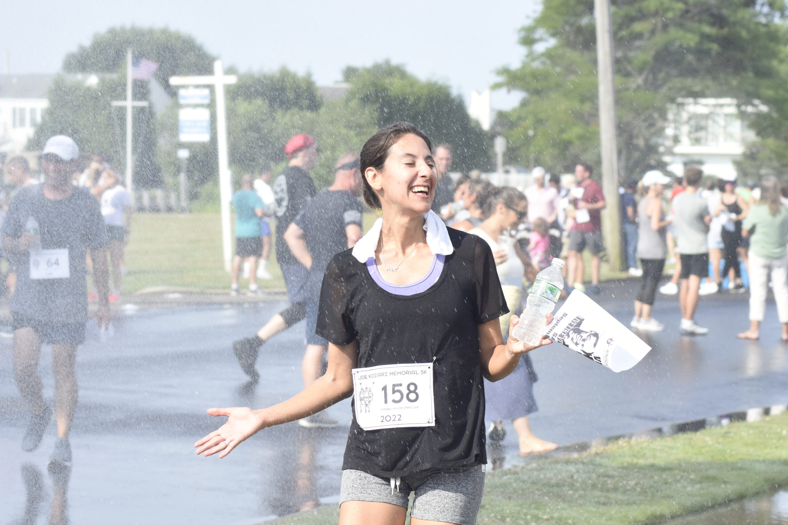 Elizabeth Oliner of East Quogue enjoys the postrace shower.    DREW BUDD