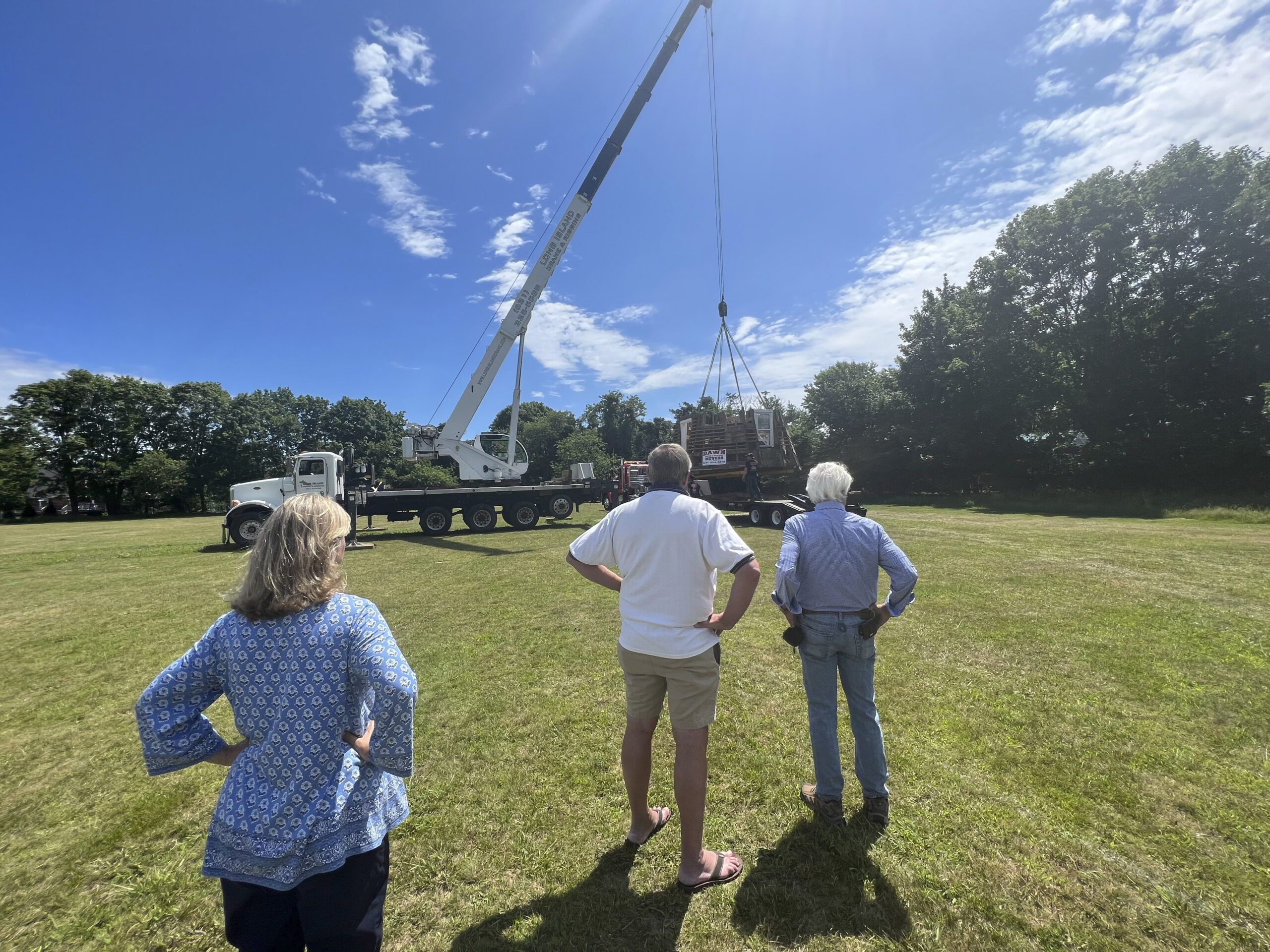 Mayor Maria Moore, Trustee Ralph Urban and Larry Jones watch as the first section of the windmill is placed on the Great Lawn.   DANA SHAW