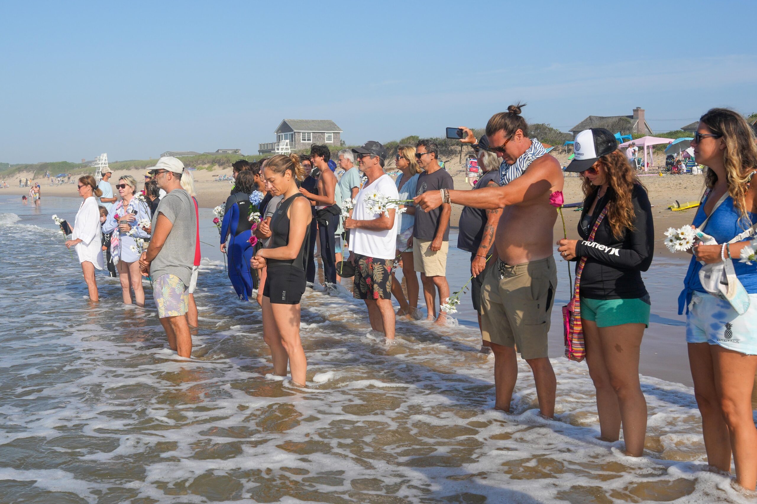 People partake in the memorial prior to surfing.    RON ESPOSITO