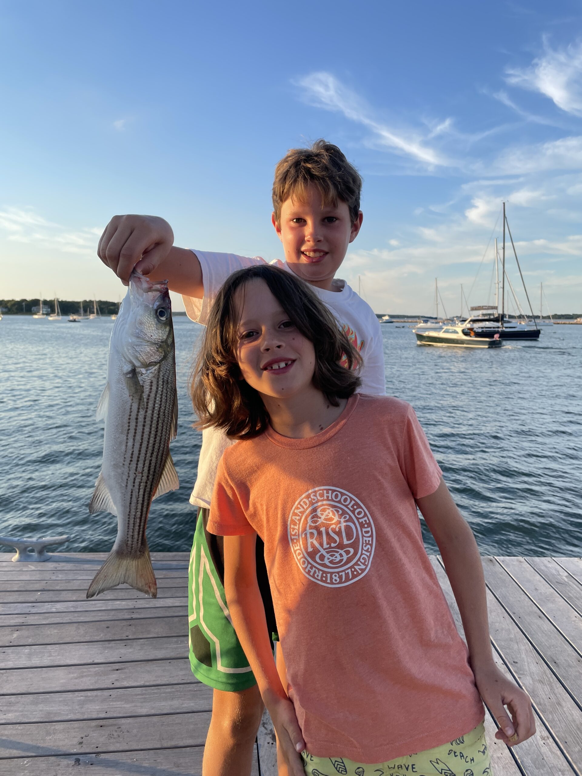 Oliver and Hugo Ross with a little striped bass they caught off Long Wharf in Sag Harbor.  MIKE WRIGHT