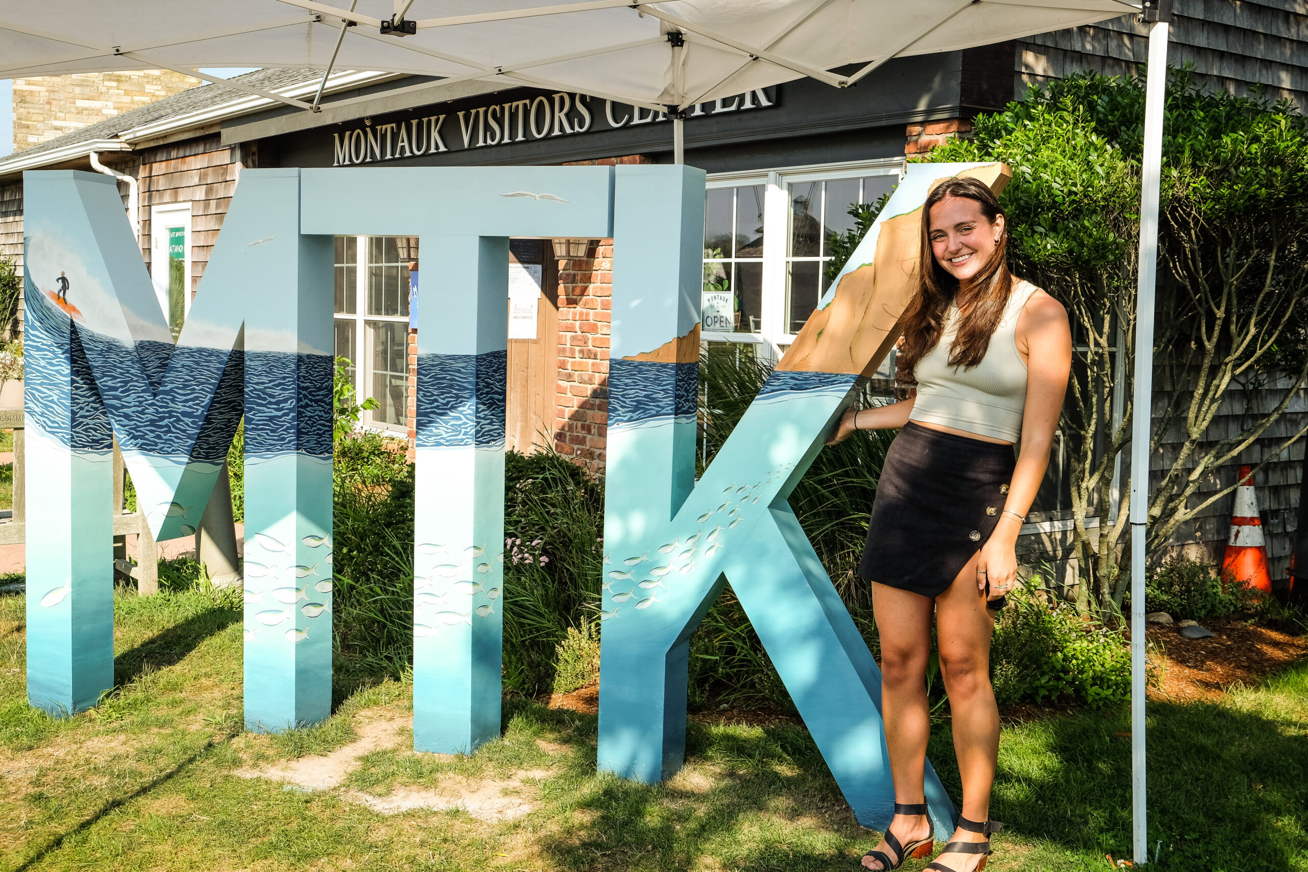 Artist Kylie Ogburn with the painted MTK letters in Montauk. IAN COOKE/COURTESY MONTAUK CHAMBER OF COMMERCE