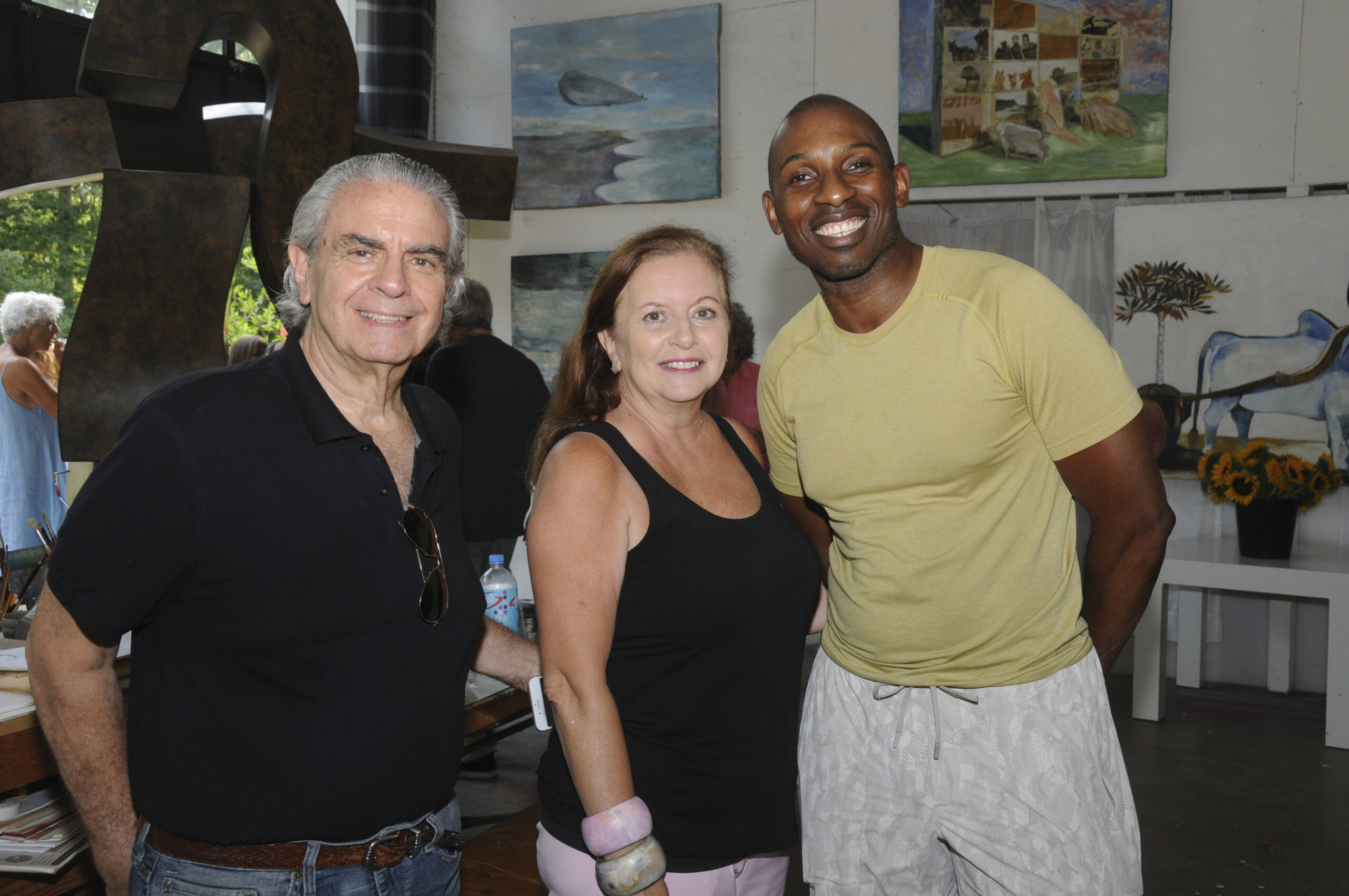 Robert and Anahi De Canio with Lancelot Francis on Friday evening at artist Hans Van de Bovenkamp's 7-acre, Sagaponack indoor/outdoor studio and sculpture gardens for the opening of an art exhibition and sale of works by  Van de Bovenkamp, Miller, Stephanie Brody-Lederman and the late Charles Waller. The Show is curated by Geralyne Lewandowski. A portion of the proceeds will benefit Maureen's Haven Homeless Outreach.   RICHARD LEWIN