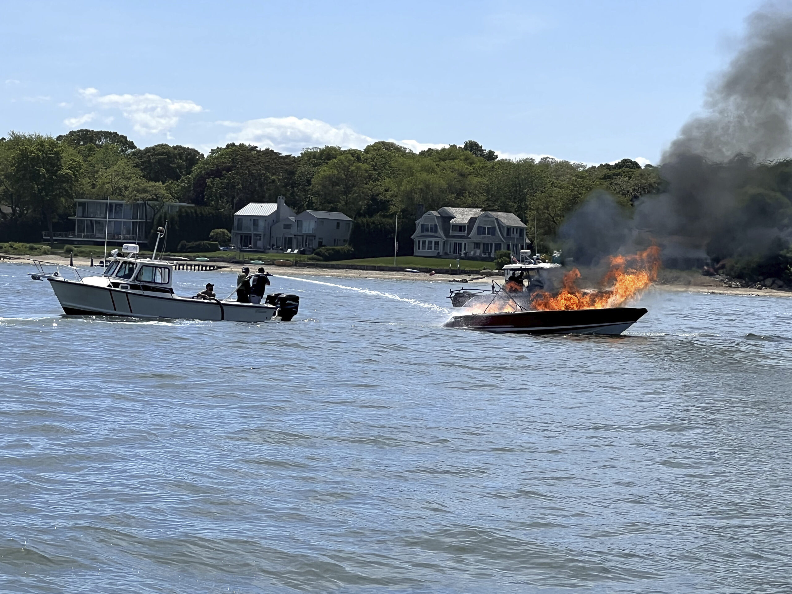 Firefighters try to douse burning powerboat last Memorial Day weekend. PETER BOODY