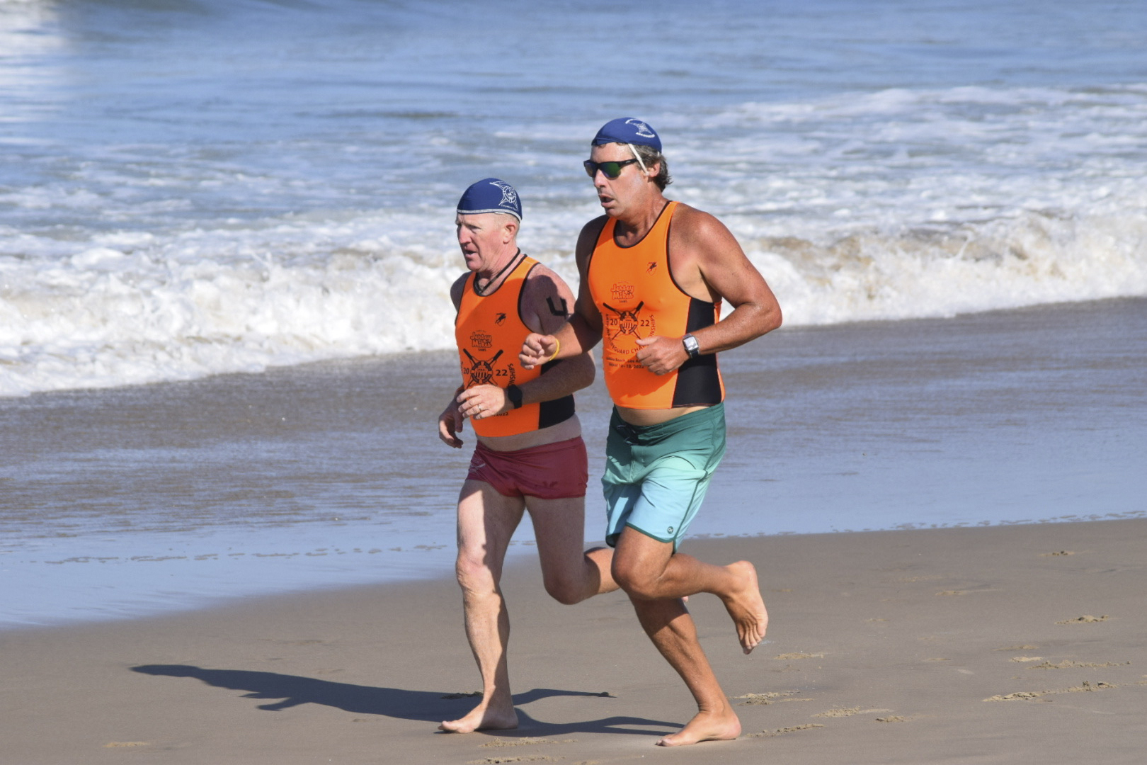 East Hampton Town’s chief lifeguard, John Ryan Jr, at left, with Jon Tarbet in the distance run.                        NICOLE CASTILLO