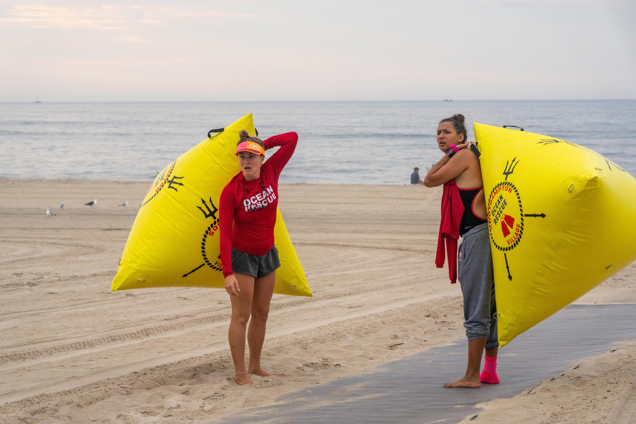 Southampton Village Volunteer Ocean Rescue members Alexandra Talty, left, and Natasha Faradkin get ready to set up the course.   RON ESPOSITO