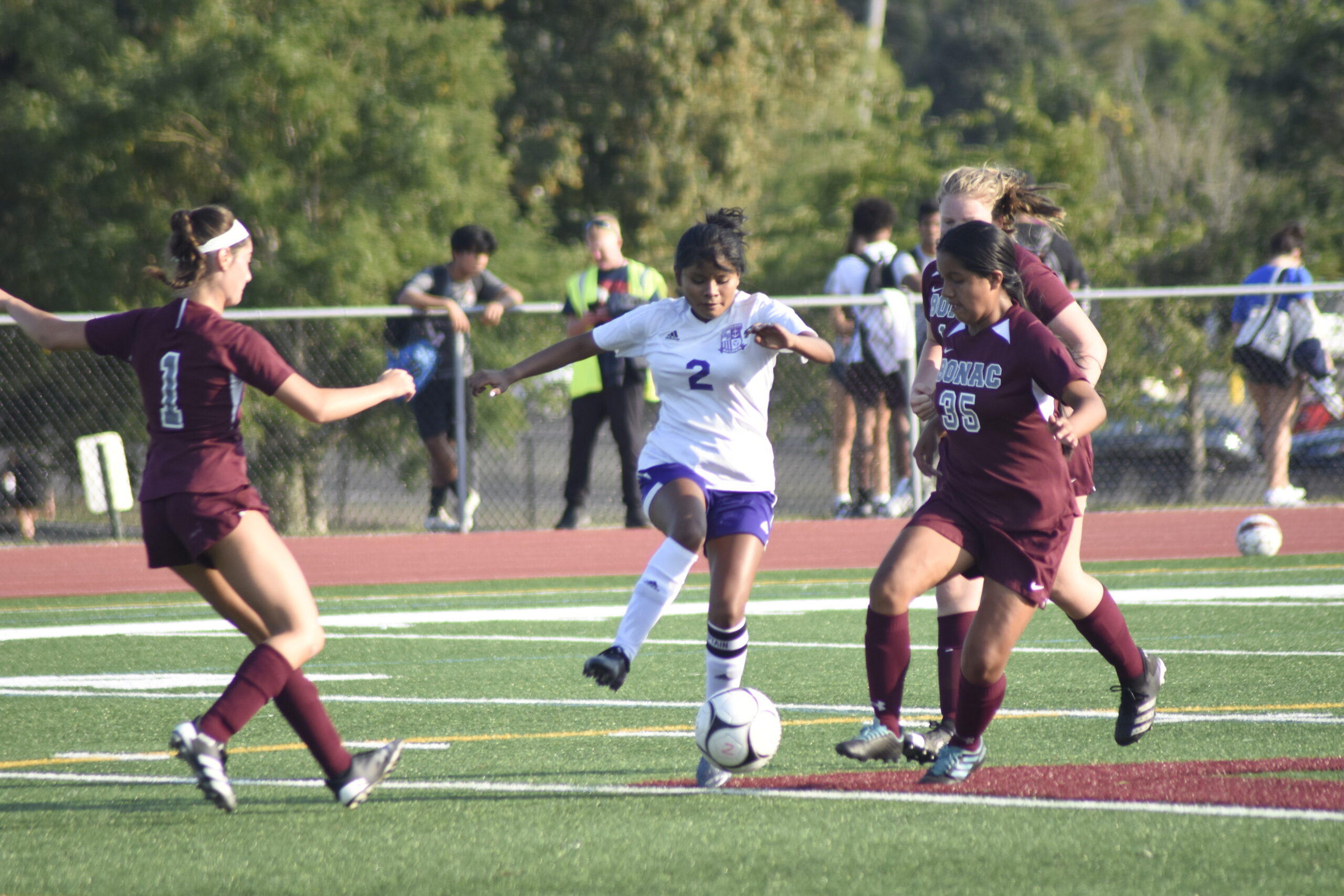 Hampton Bays senior Arlette Amador settles a ball between Bonackers Wyeth Zeff (1) and Kaylee Munoz.    DREW BUDD