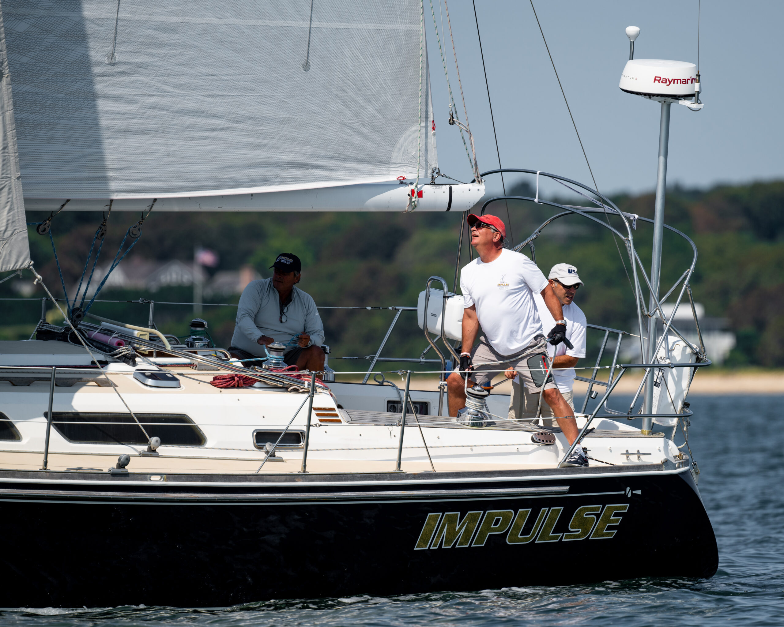Members of Impulse, skippered by Andrew Baris, check their sails.     GARY SENFT/EASTENDMARINEPHOTOGRAPHY.COM