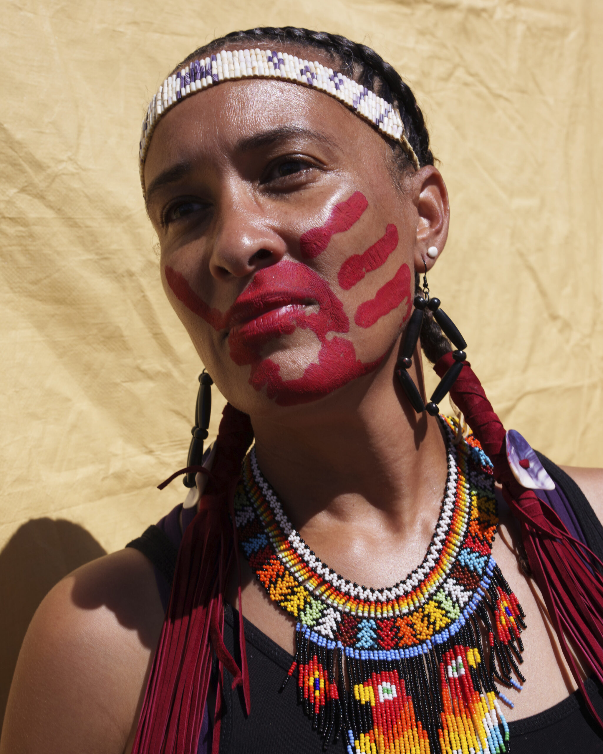 A woman attending the Shinnecock Nation powwow painted a red handprint over her mouth to bring awareness to MMIW - Missing and Murdered Indigenous Women