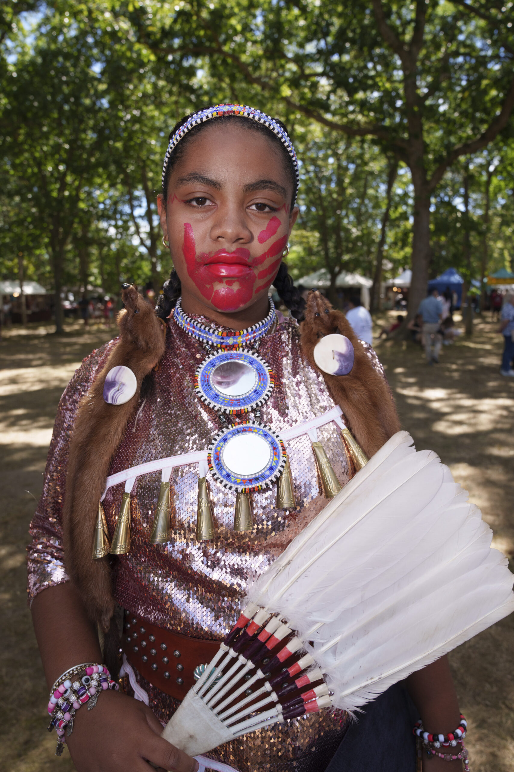 A girl attending the Shinnecock Nation powwow painted a red handprint over her mouth to bring awareness to MMIW - Missing and Murdered Indigenous Women