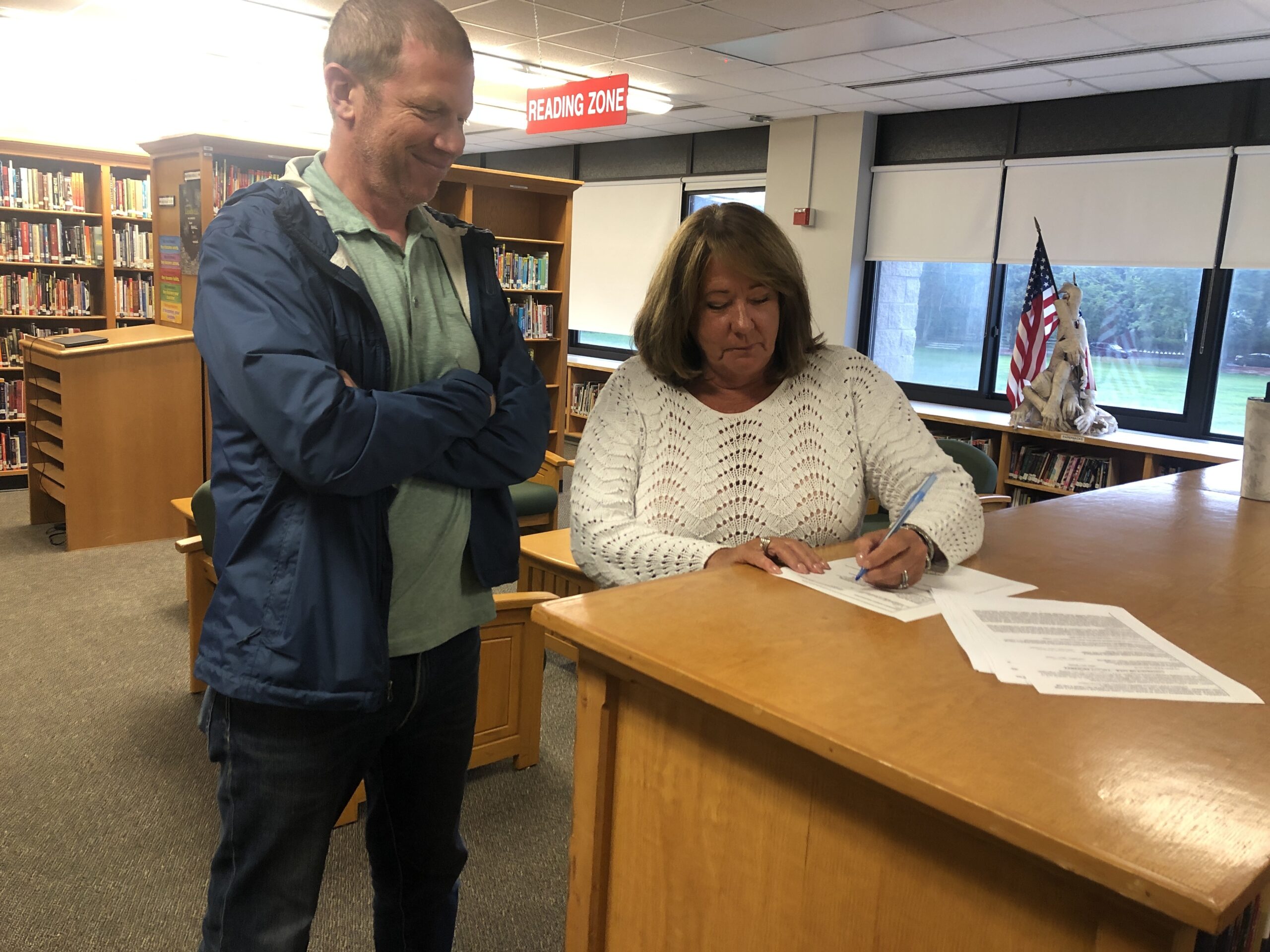 Sag Harbor School Board President Sandi Kruel signs an agreement to purchase a three-quarter acre lot on Marsden Street with money from the district's capital reserves. Pending voter approval, the district will buy that lot, along with four other adjoining lots on the street, with help from the Southampton Town Community Preservation Fund, and will build an athletic facility there. CAILIN RILEY PHOTOS