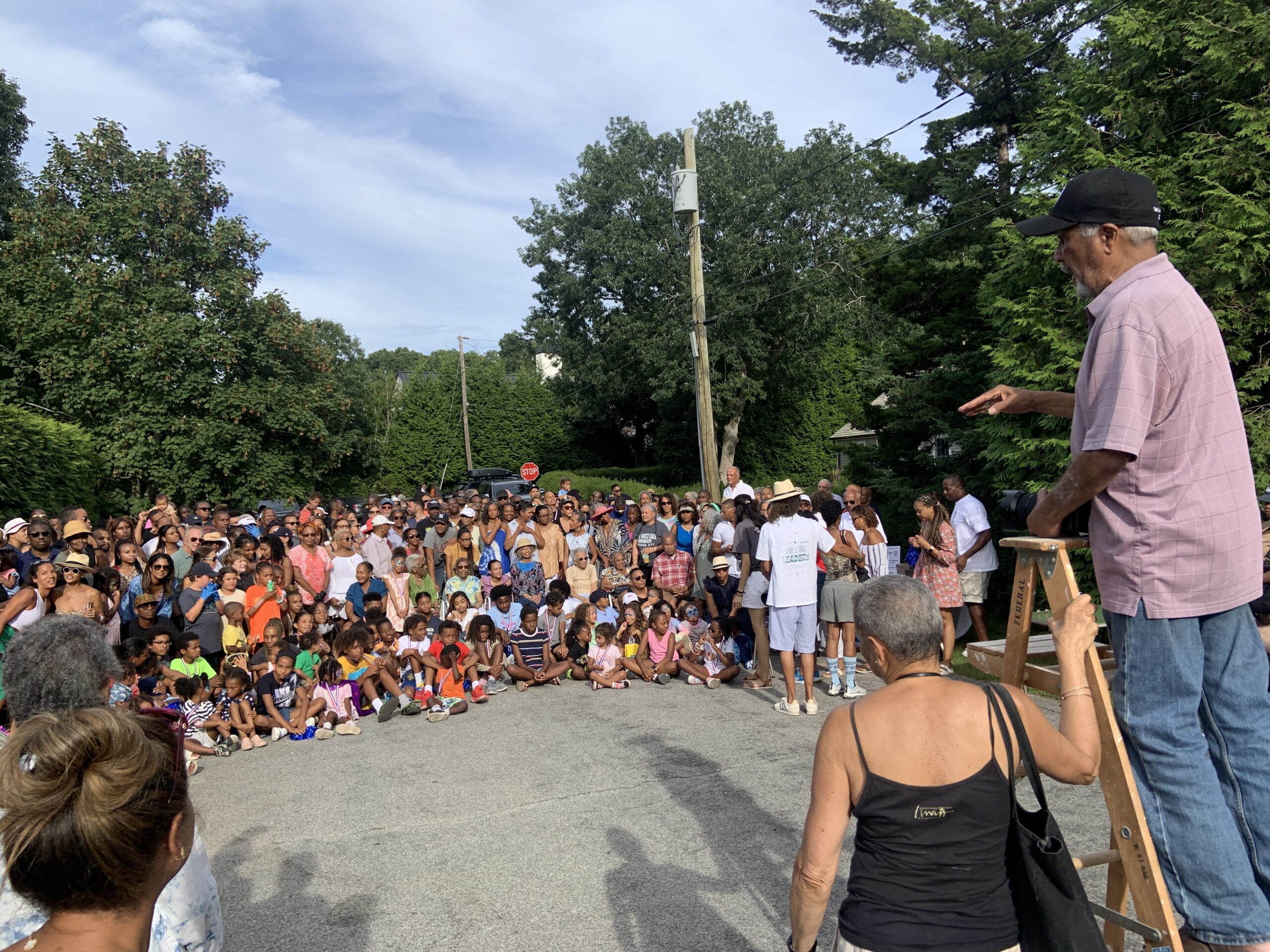 Photographer John Pinderhughes had the unenviable task of trying to organize for a group photo  the hundreds of people who showed up for the annual Sag Harbor Hills Labor Day block party. STEPHEN J. KOTZ