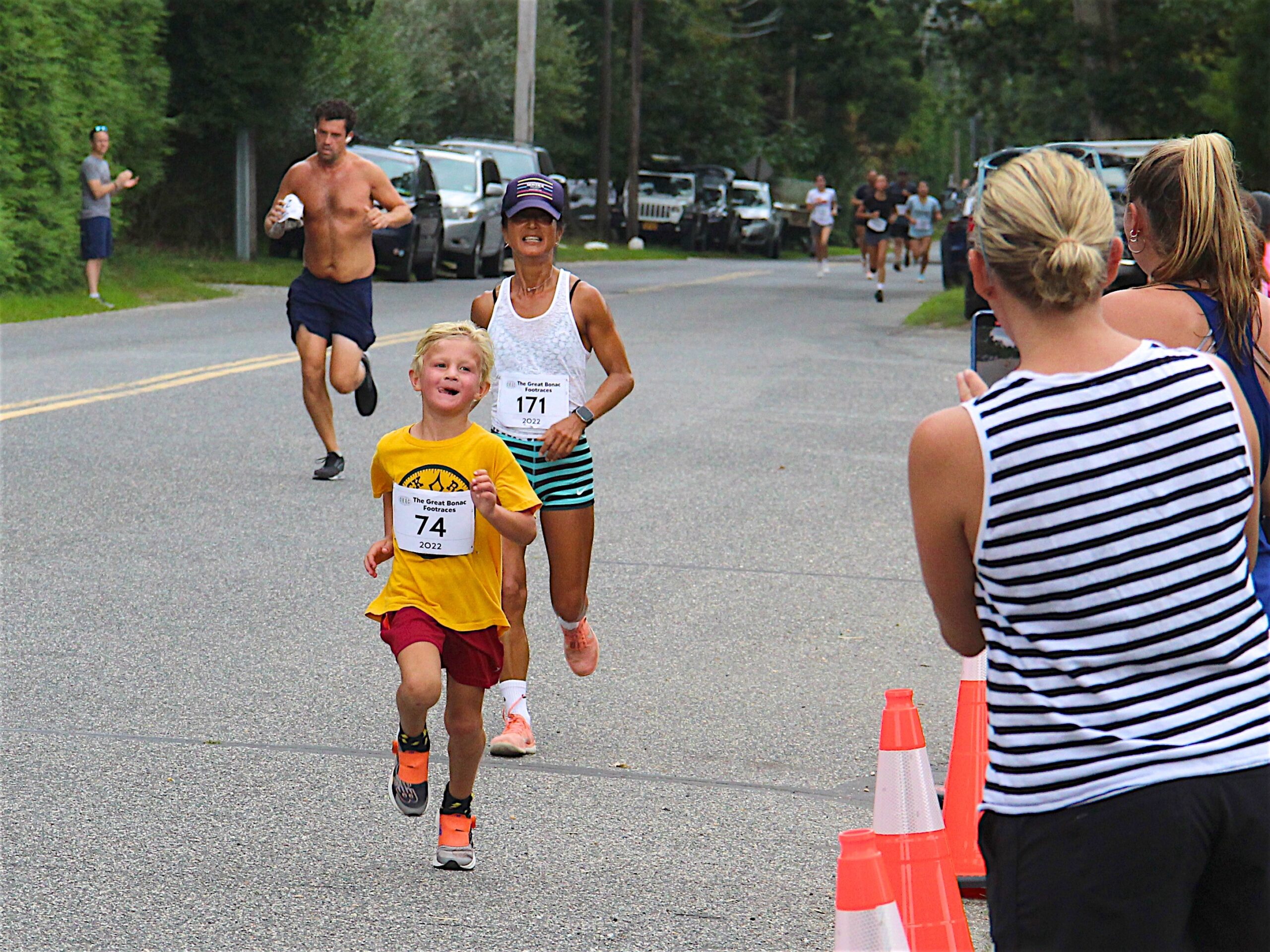 Henry Schippers, 6, of Brooklyn races toward the finish line with Beth Feit of East Hampton close on his trail.   KYRIL BROMLEY