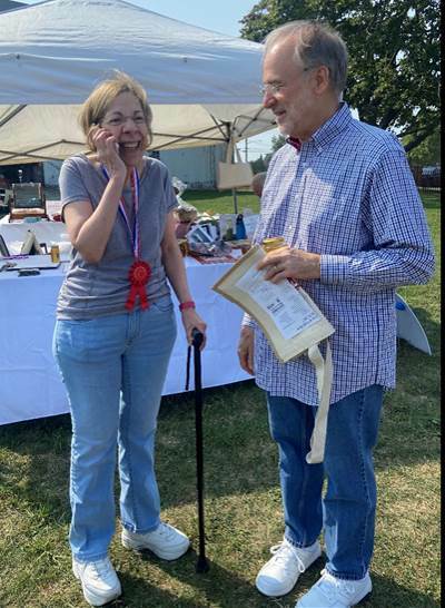 Second-place honey winner, Edward Lessard, of Belle Terre, looks on as his wife shares news of their victory at the Hallockville Museum Farm’s Jam and Honey Competition. COURTESY HALLOCKVILLE MUSEUM FARM