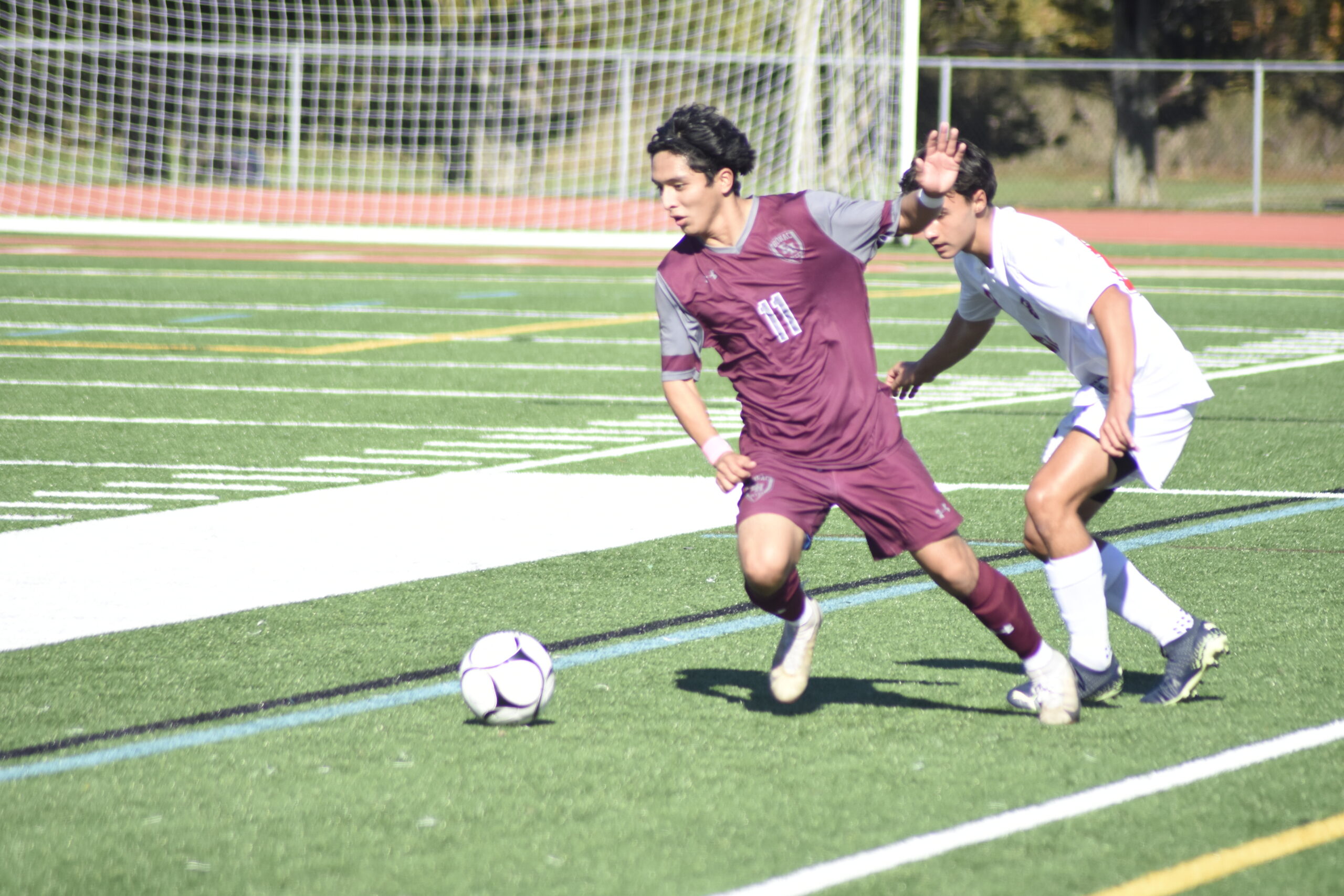 Junior Bonacker Gary Gutama fends off an East Islip player.    DREW BUDD