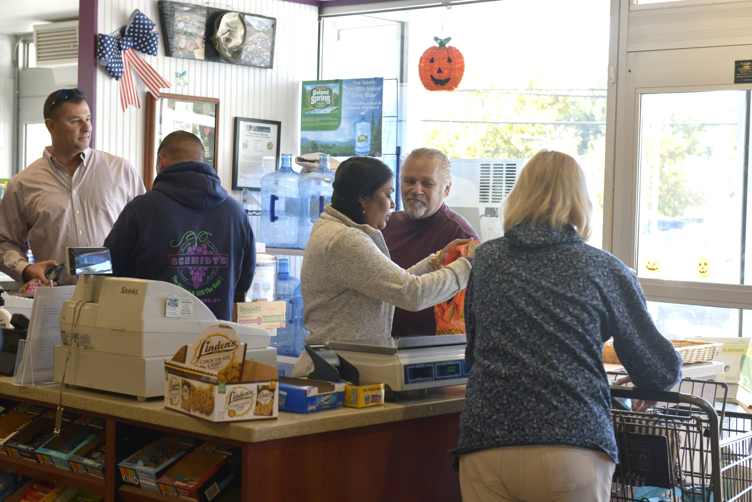 Dan and Dennis Schmidt check out customers and say their goodbyes on Friday at Schmidt's Market.  DANA SHAW