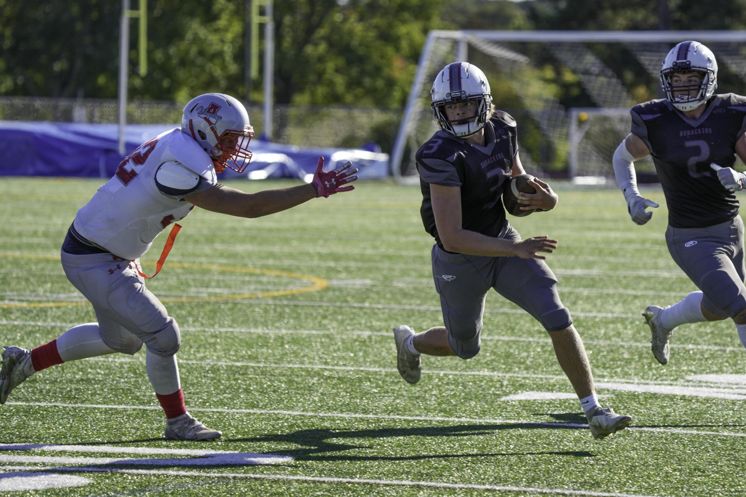 East Hampton junior quarterback Charlie Corwin looks to avoid an Amityville defender.   RON ESPOSITO