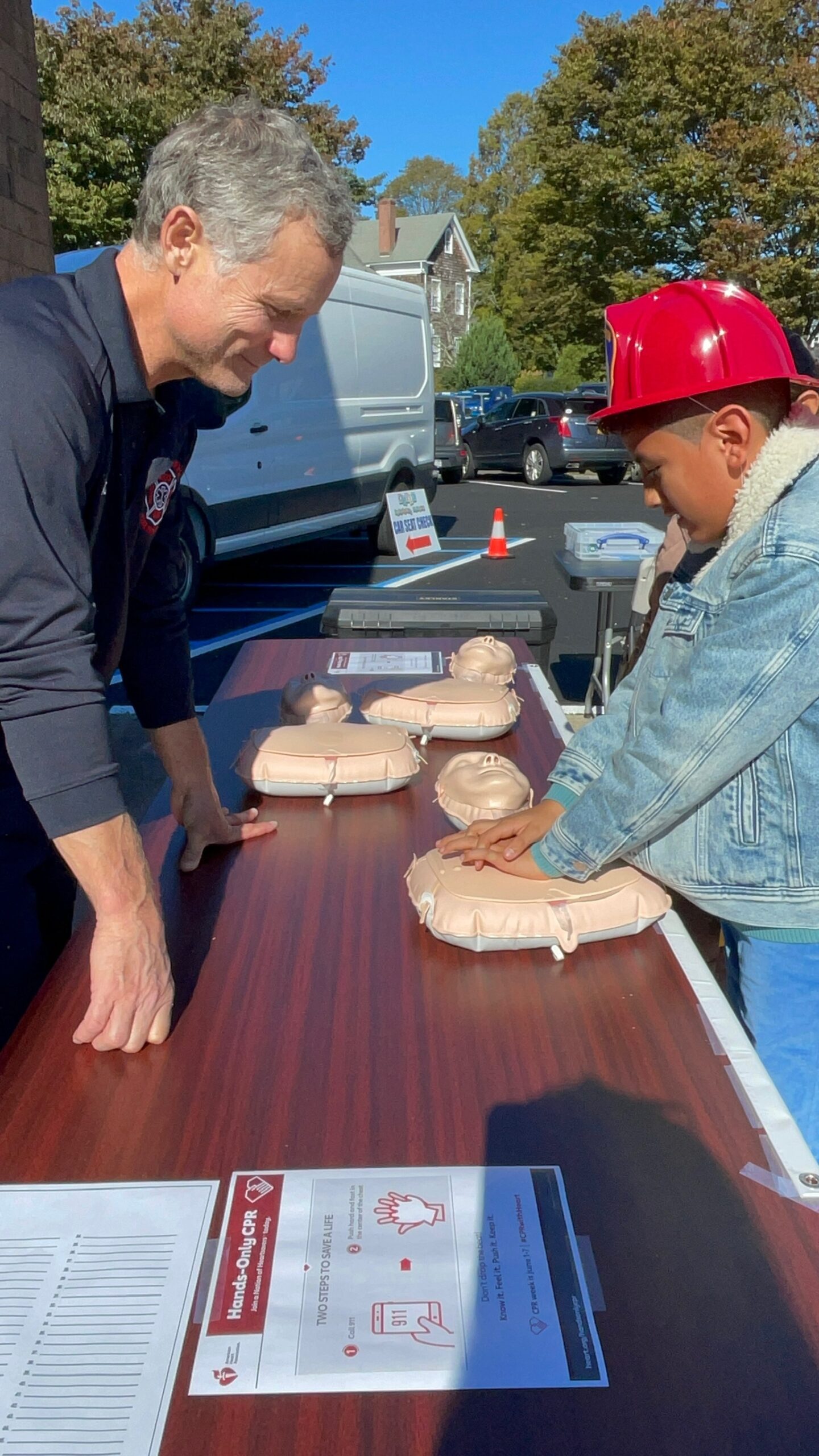 Paramedic and Second Assistant EMS Captain Joe Louchheim teaching Dominic Uzhca about hands-only CPR at the Bridgehampton Fire Department’s open house on Saturday. COURTESY BRIDGEHAMPTON FIRE DEPARTMENT