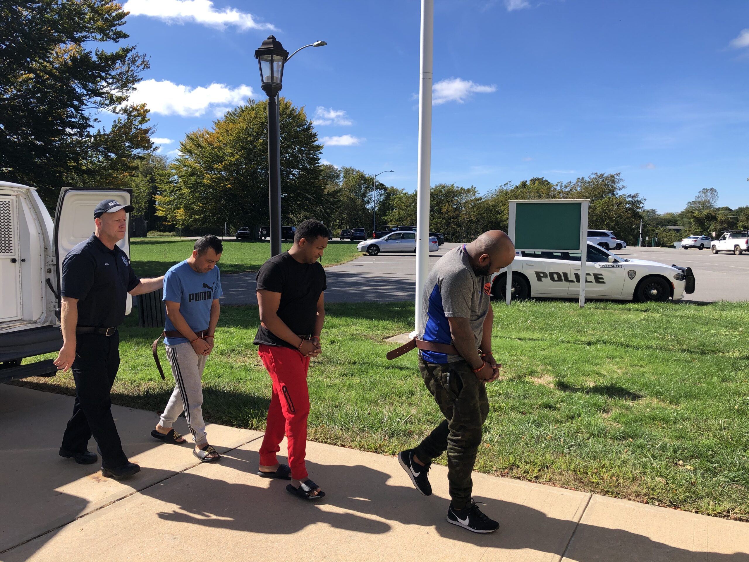 Angel Garces Diaz on the right, followed by Anuedis Garces Medrano and Everado Hernandez, being brought by police into East Hampton Town Justice Court October 6 to be arraigned on cocaine dealing charges. T.E. MCMORROW