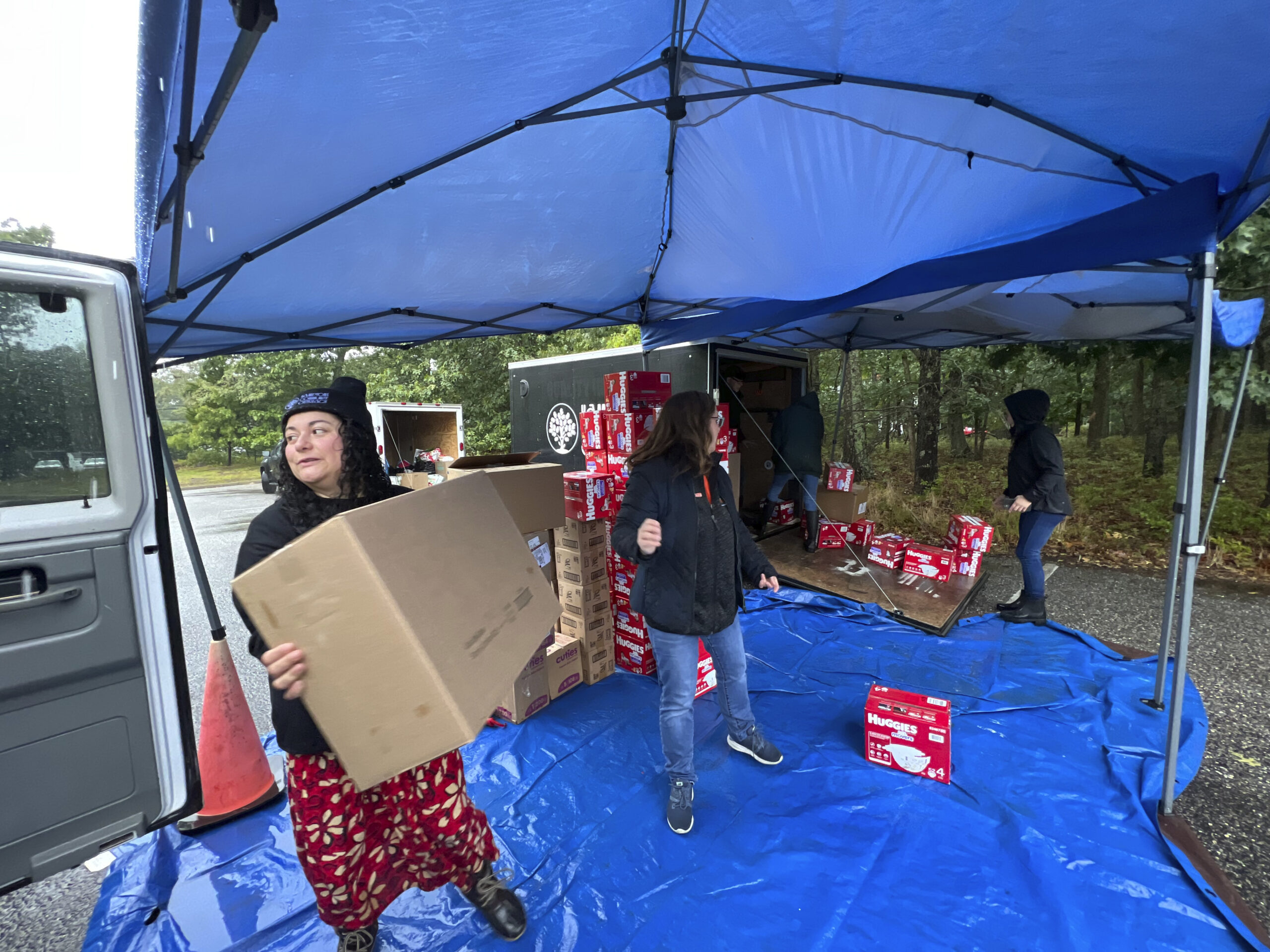 Ale Monroy and Heather Edwards distribute diapers on a rainy Saturday in the parking lot at the Unitarian Universalist Church in Bridgehampton.  DANA SHAW