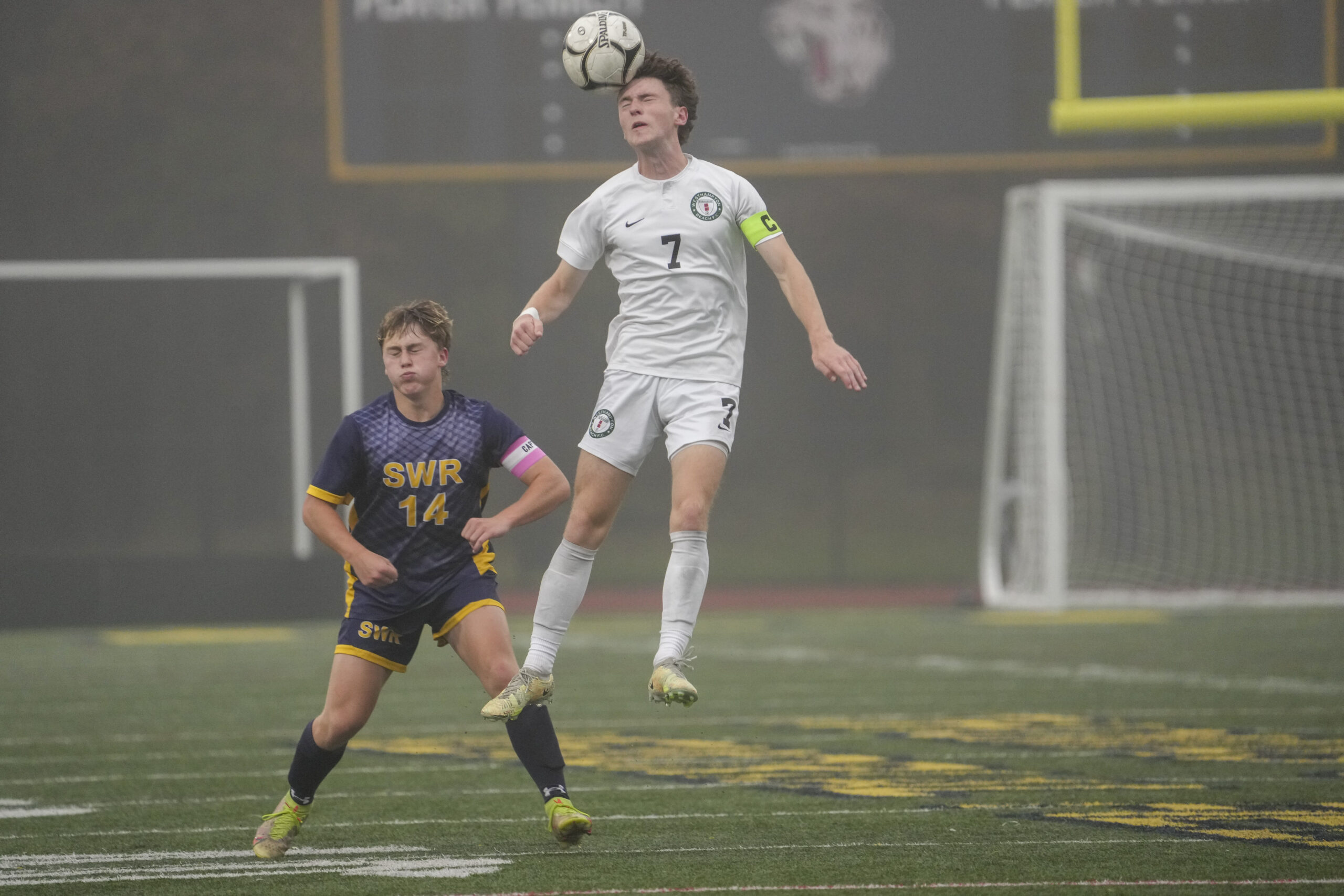 Westhampton Beach senior co-captain Ethan Vogt heads the ball at midfield.   RON ESPOSITO